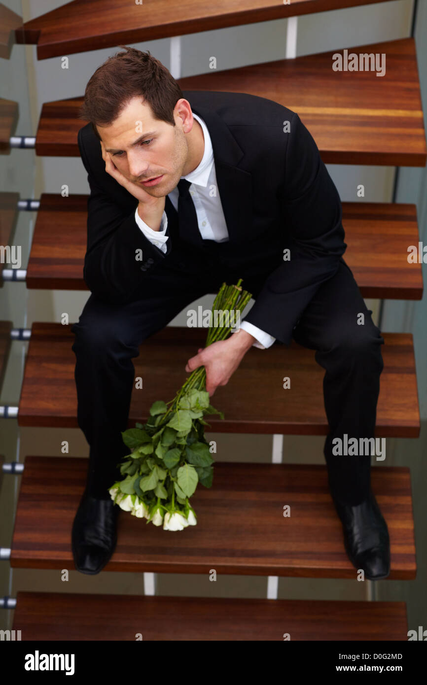Young gentleman, sits quietly moping after having a spat with his girlfriend Stock Photo
