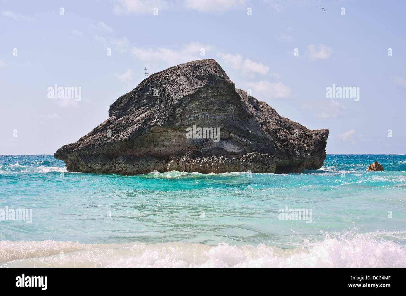 A large rock in the Atlantic ocean in the coastal waters of Bermuda. Photo was taken at Horseshoe Bay in Bermuda. Stock Photo