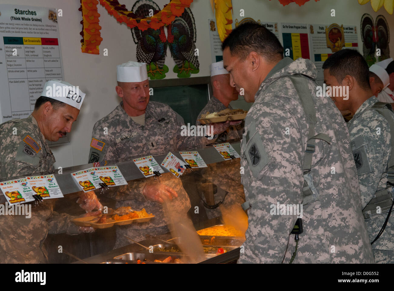 Unit commanders, officers, and first sergeants serve a Thanksgiving meal to soldiers and civilians at Camp Bondsteel, Kosovo. The dining facility provided a cornucopia of food from prime rib and turkey, to pecan pie. The facility managers took extra effor Stock Photo