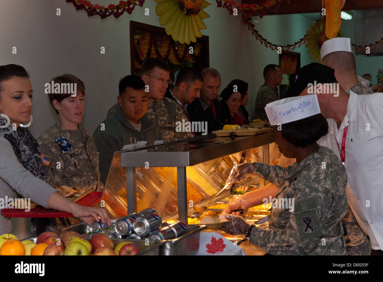 Unit commanders, officers, and first sergeants serve a Thanksgiving meal to Soldiers and civilians at Camp Bondsteel, Kosovo. The dining facility provided a cornucopia of food from prime rib and turkey, to pecan pie. The facility managers took extra effor Stock Photo