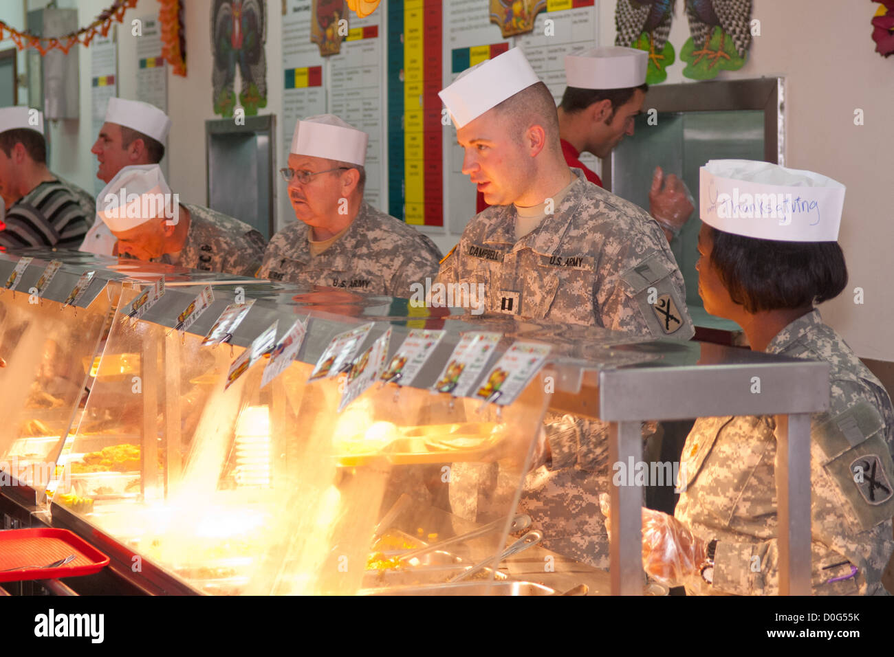 Unit commanders, officers, and first sergeants serve a Thanksgiving meal to Soldiers and civilians at Camp Bondsteel, Kosovo. The dining facility provided a cornucopia of food from prime rib and turkey, to pecan pie. The facility managers took extra effor Stock Photo