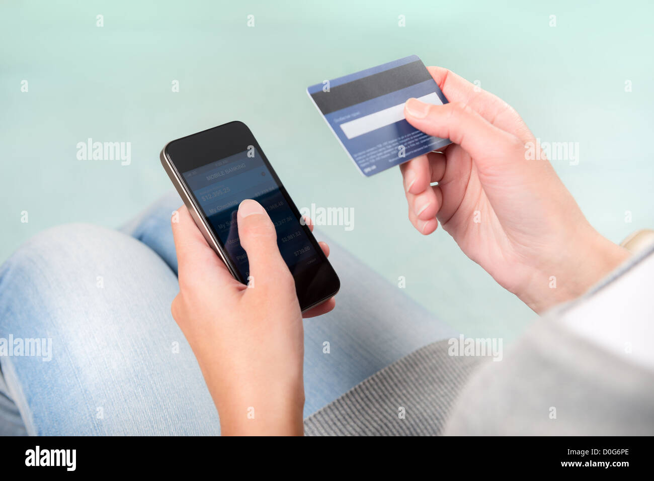 Woman verifies account balance on smartphone with mobile banking application. Stock Photo