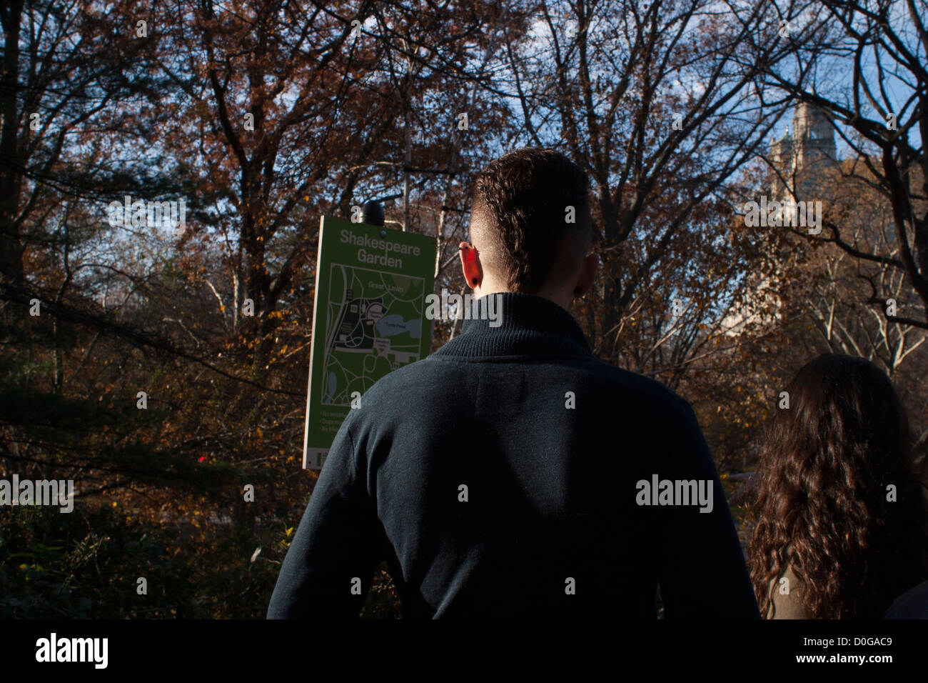 Visitors read the map posted in the Shakespeare garden in New York's Central Park. Stock Photo