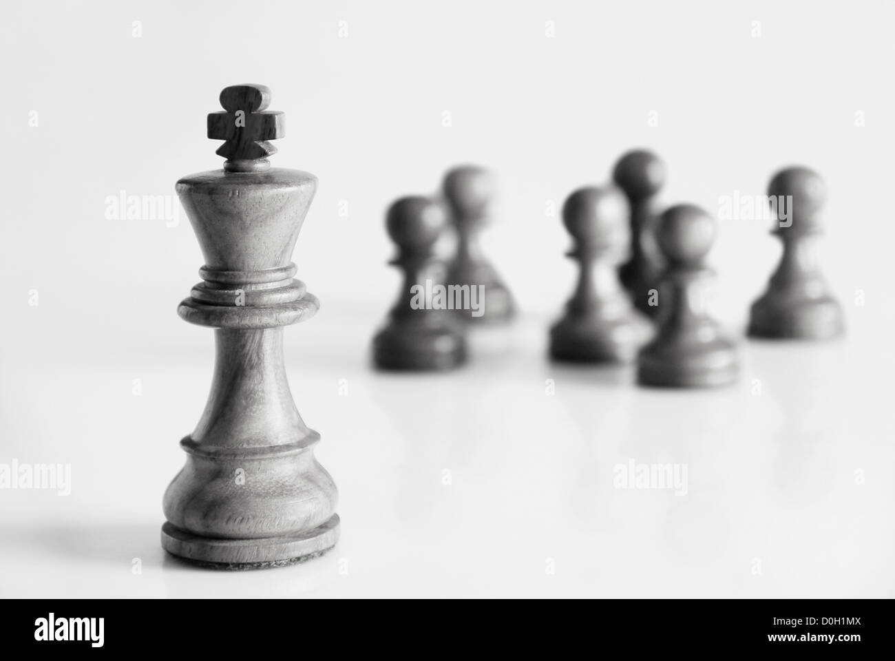 King with chess pawns in the background Stock Photo