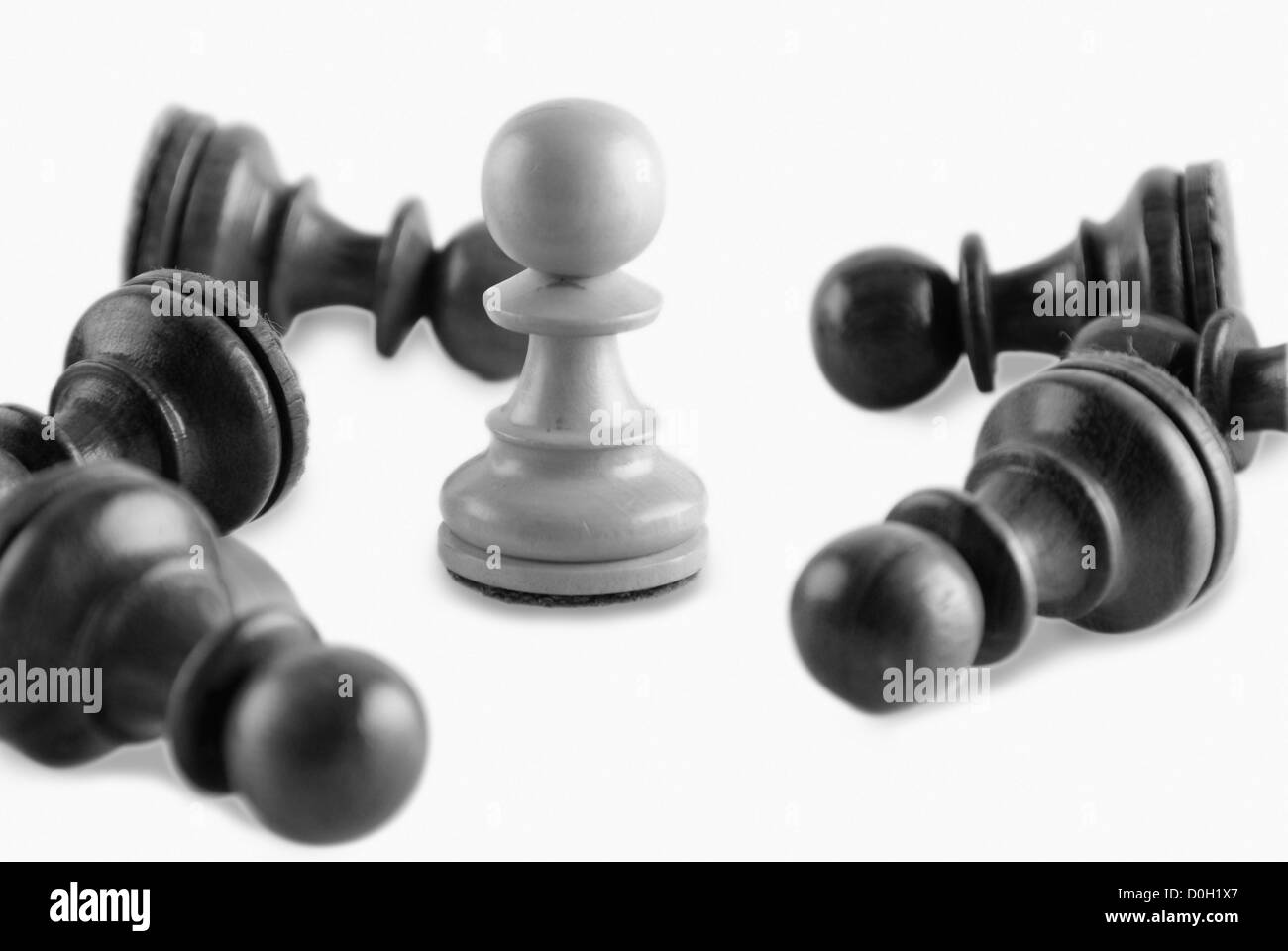 White chess pawn surrounded by black chess pawns Stock Photo