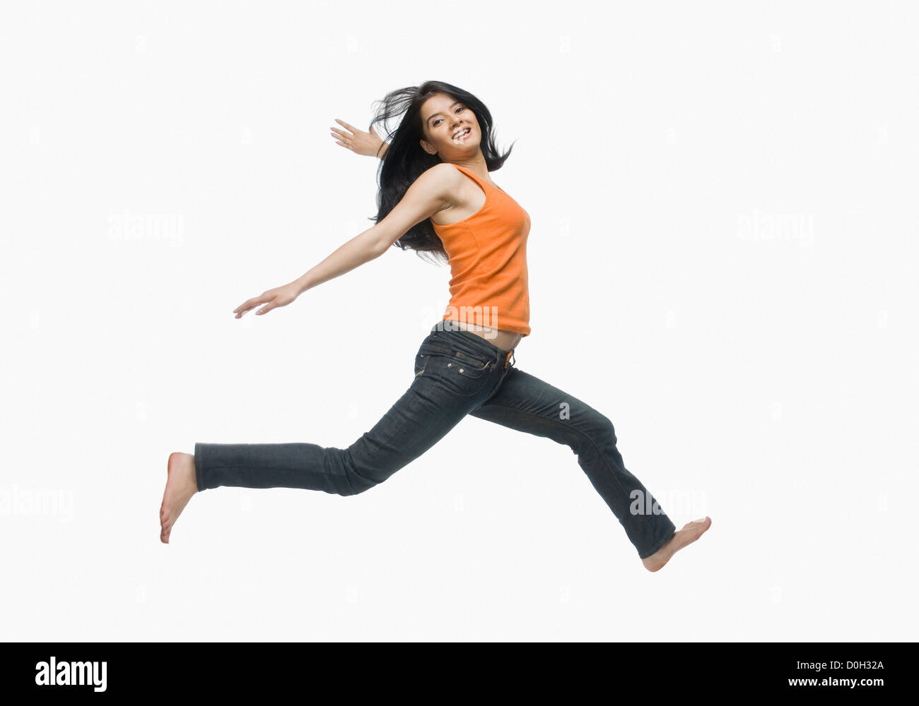 Young woman jumping against white background Stock Photo