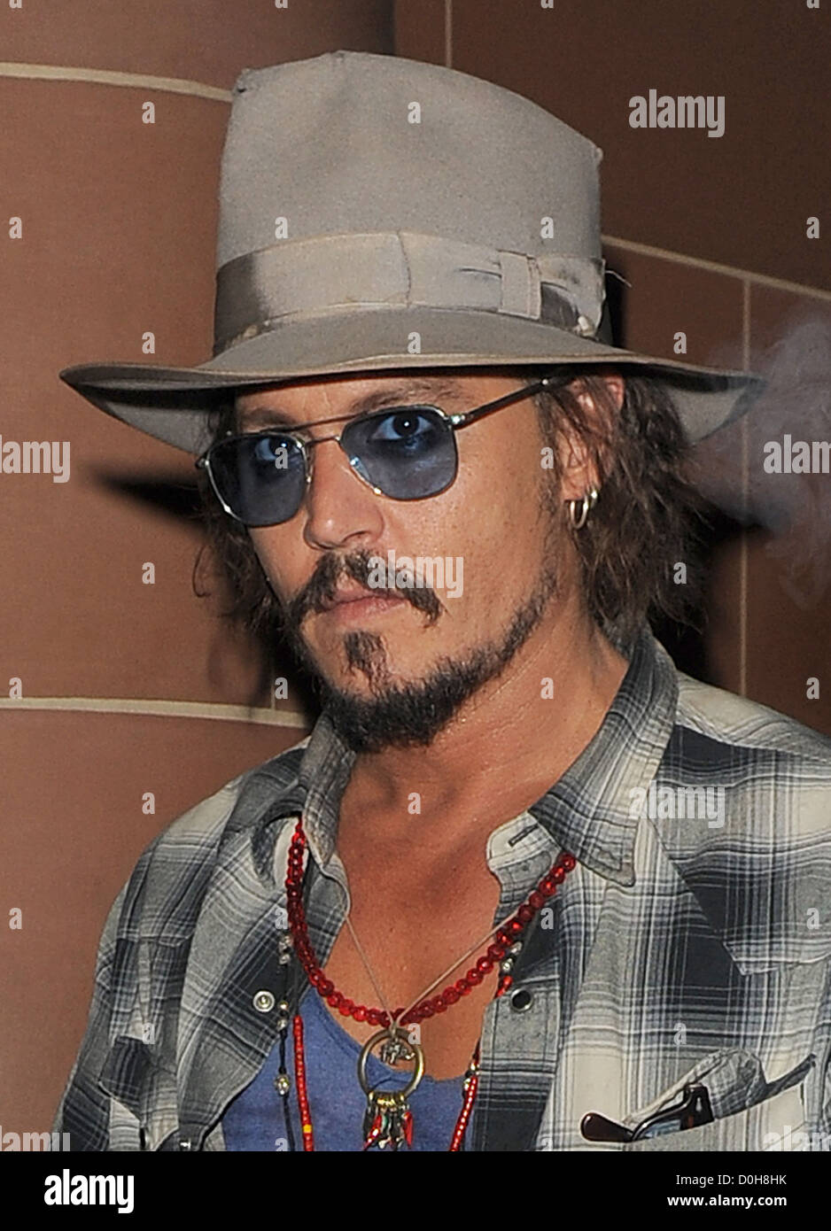 Johnny Depp, wearing a fedora hat and sunglasses, leaving 'C London'  restaurant. Depp was sporting some cuts on his face, and a Stock Photo -  Alamy