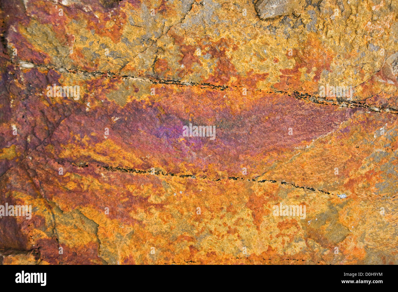 Mineral residue water running over large rock leaves colorful patina ...