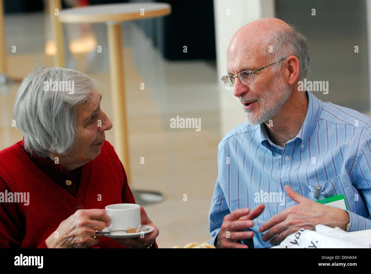 Elderly man & woman chatting during coffee break at a carers conference, London, UK. Stock Photo