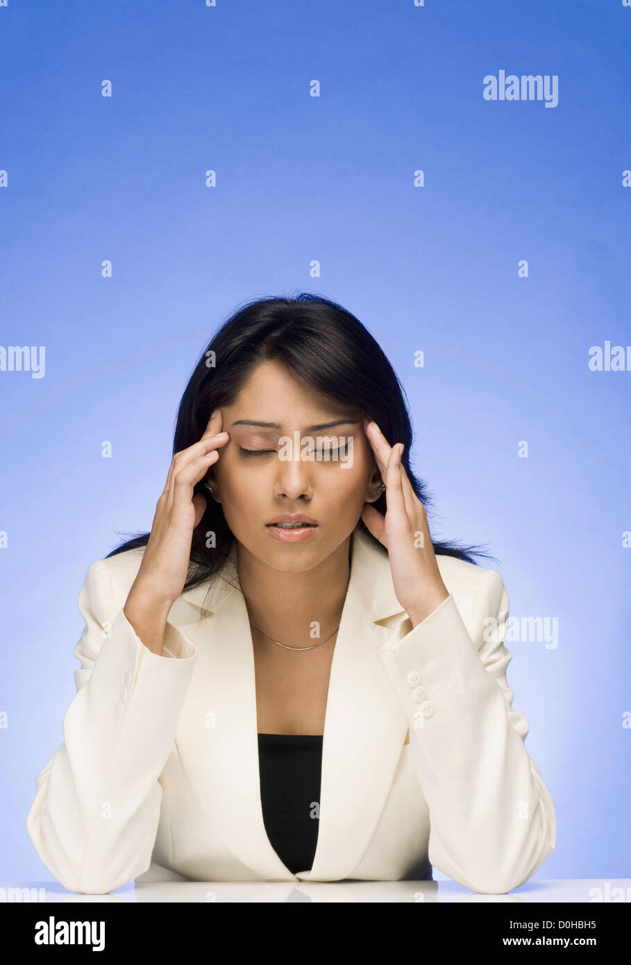 Frustrated businesswoman rubbing her temple Stock Photo