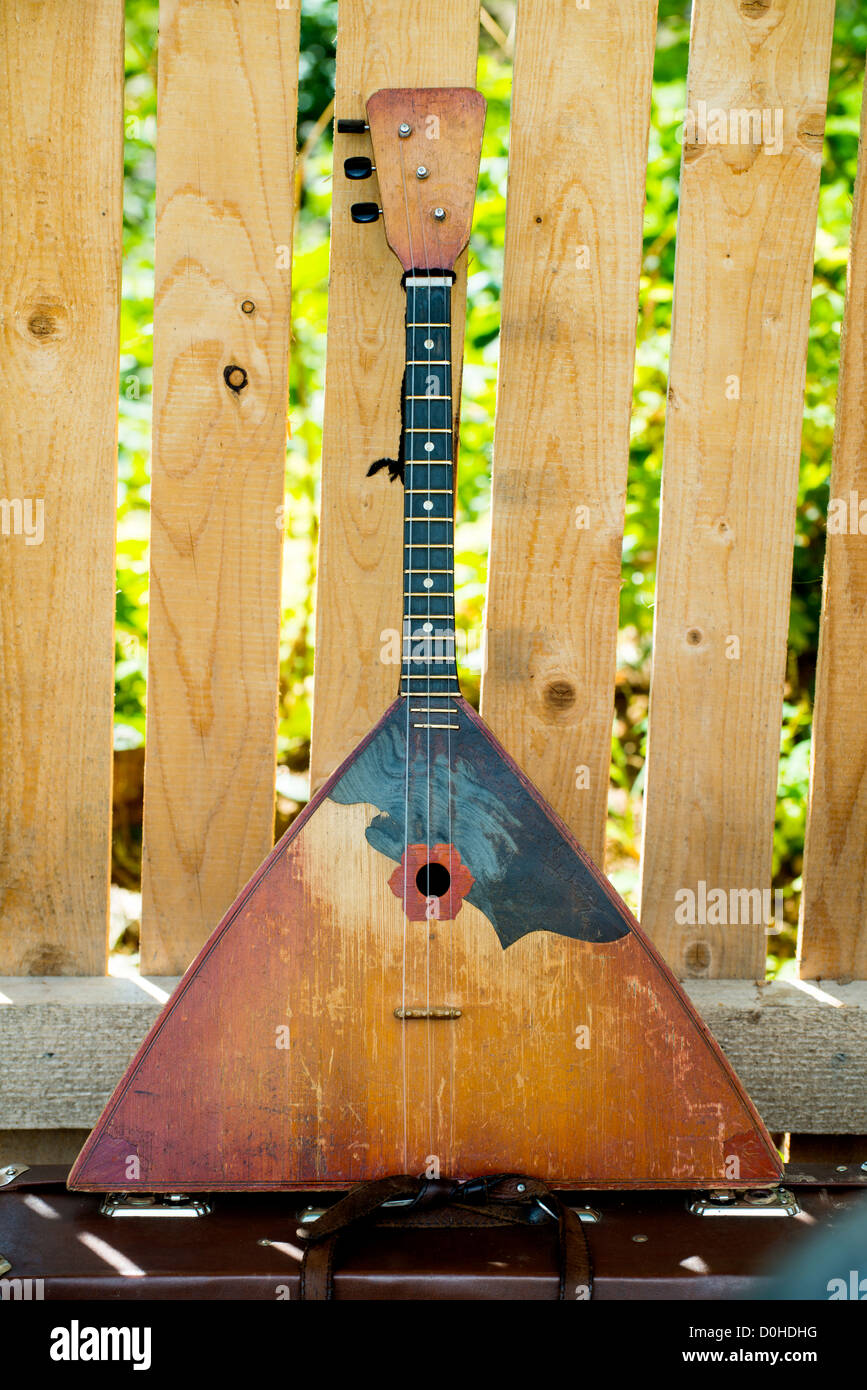 Russian balalaika a wooden fence background taken as close up. Stock Photo