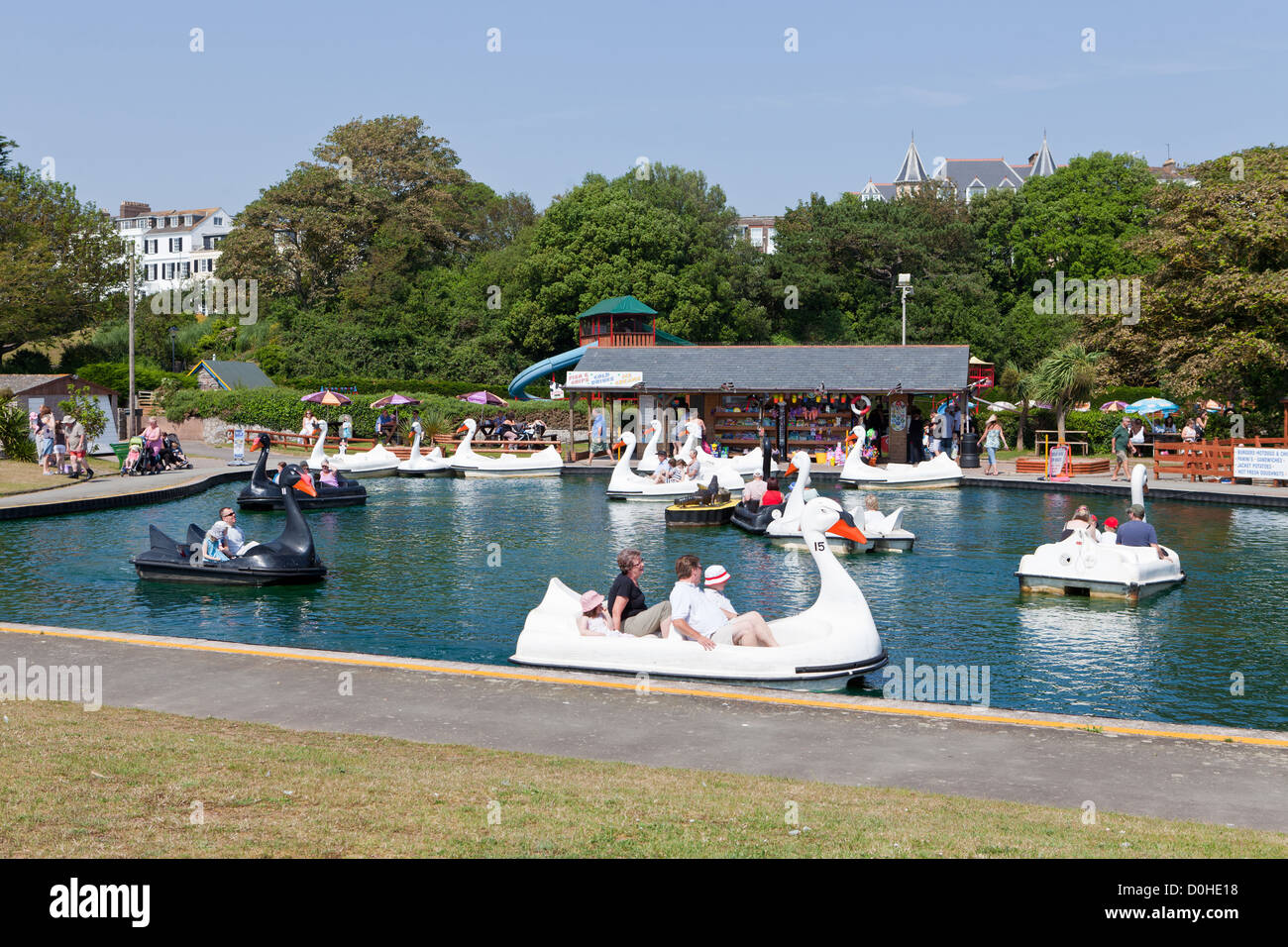 People enjoying a sunny day on the fab swan boat pool in the Exmouth Fun Park on Queen's Drive, Exmouth, UK Stock Photo