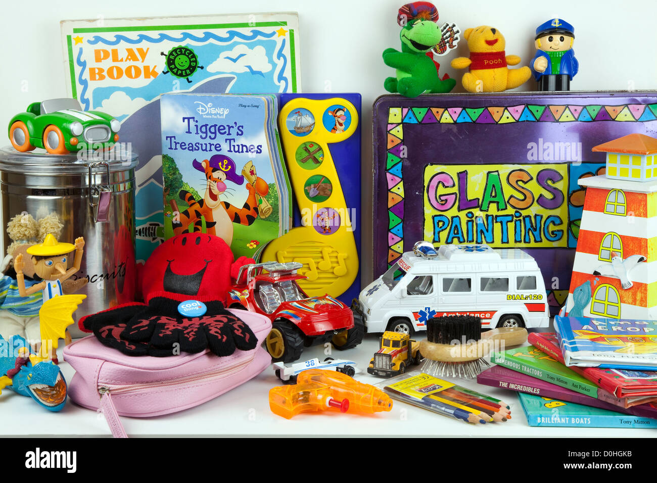 Assorted Childrens soft toys on shelf including miniature cars, teddy