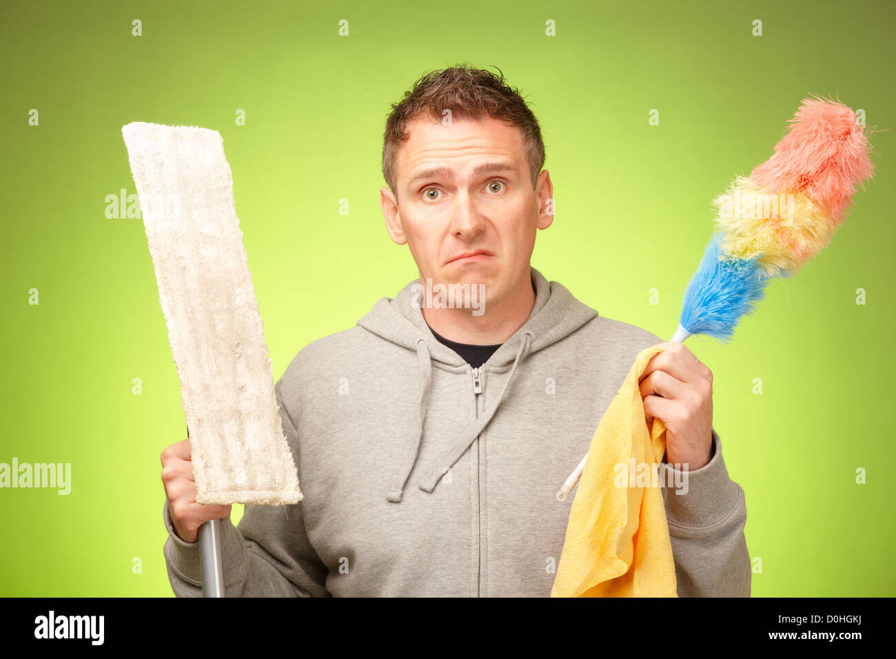 Man unhappy, confused and unsure being not prepared to clean a house Stock Photo