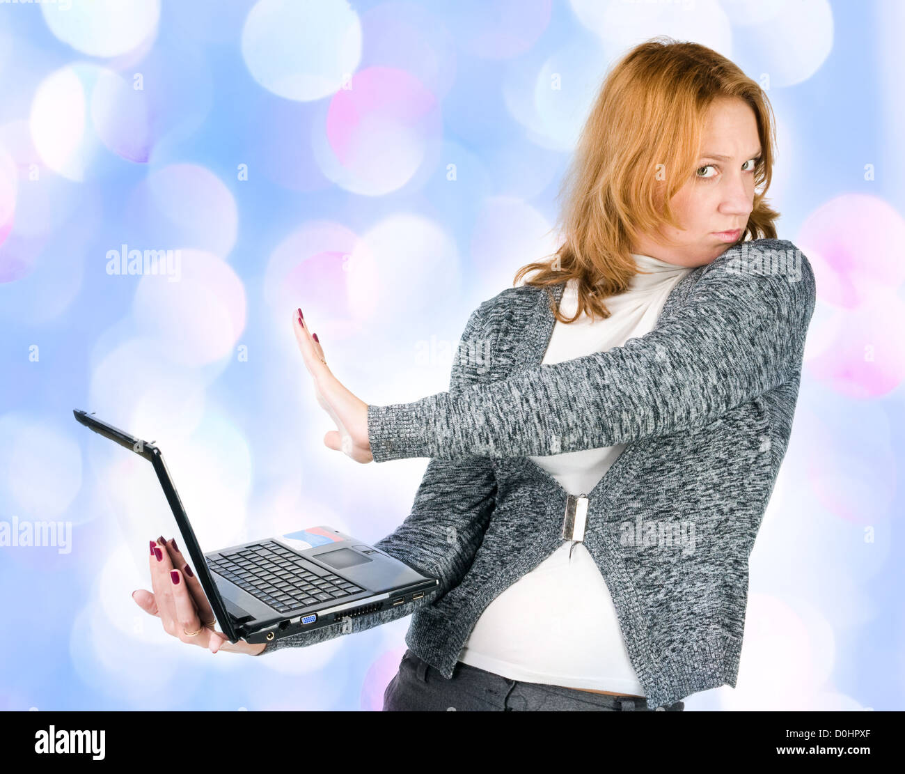 girl does not wish to work on the laptop with blue lights in the background Stock Photo