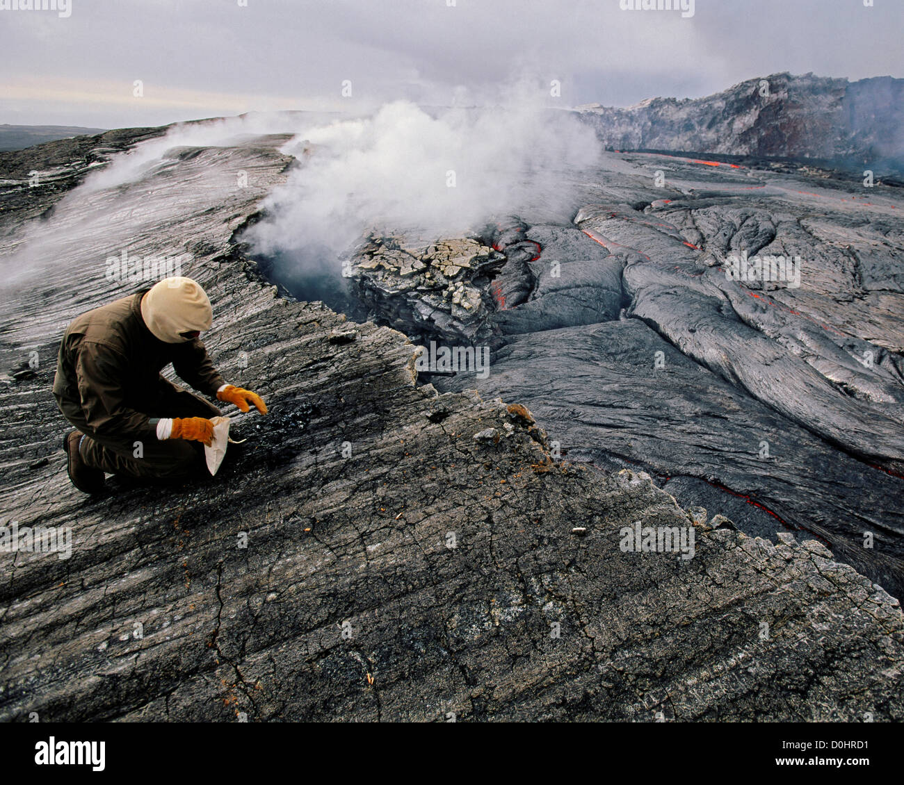 A Scientist Takes a Lava Sample on Kilauea Volcano, Hawaii Stock Photo