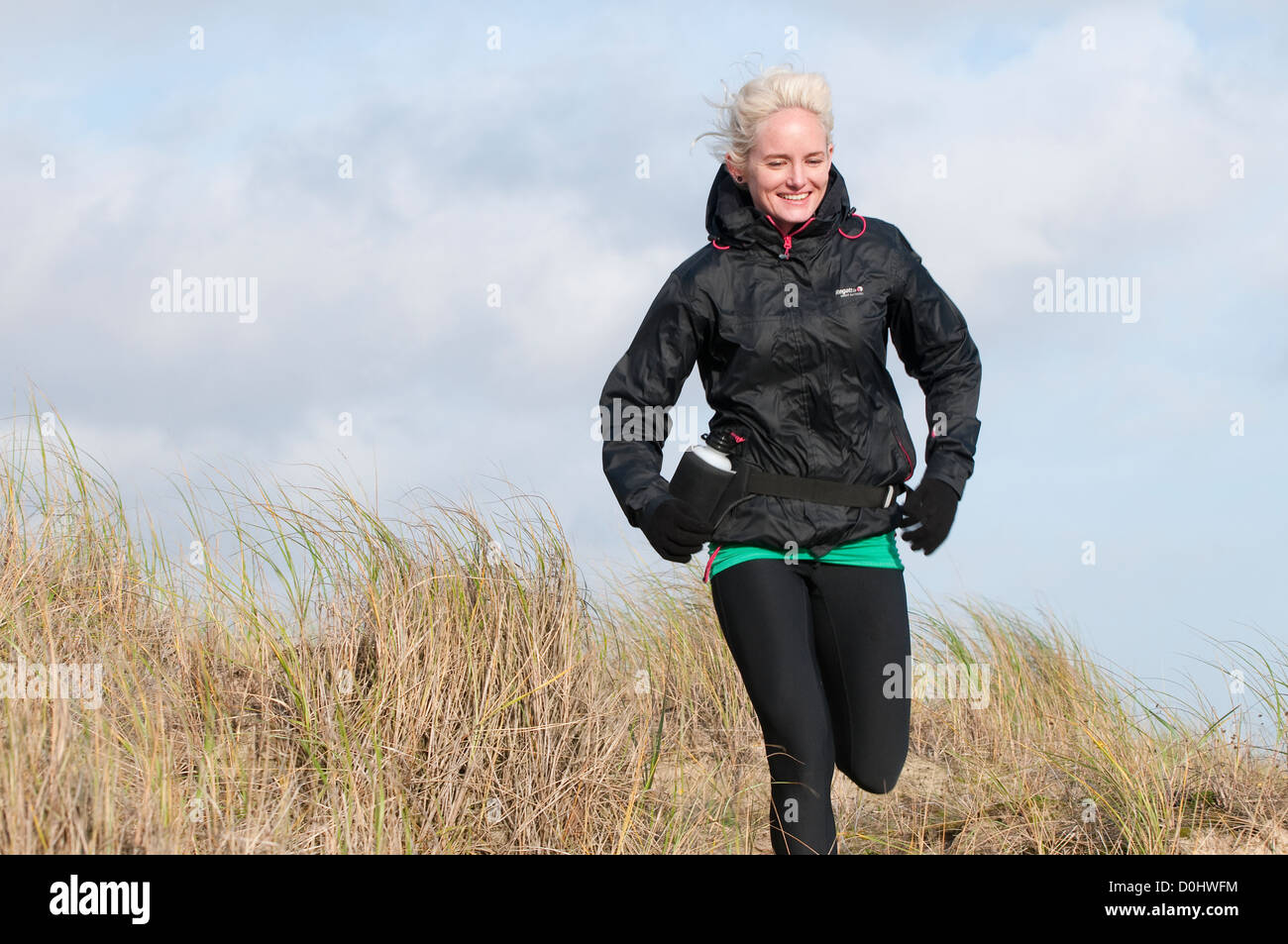 female jogger running on beach Stock Photo