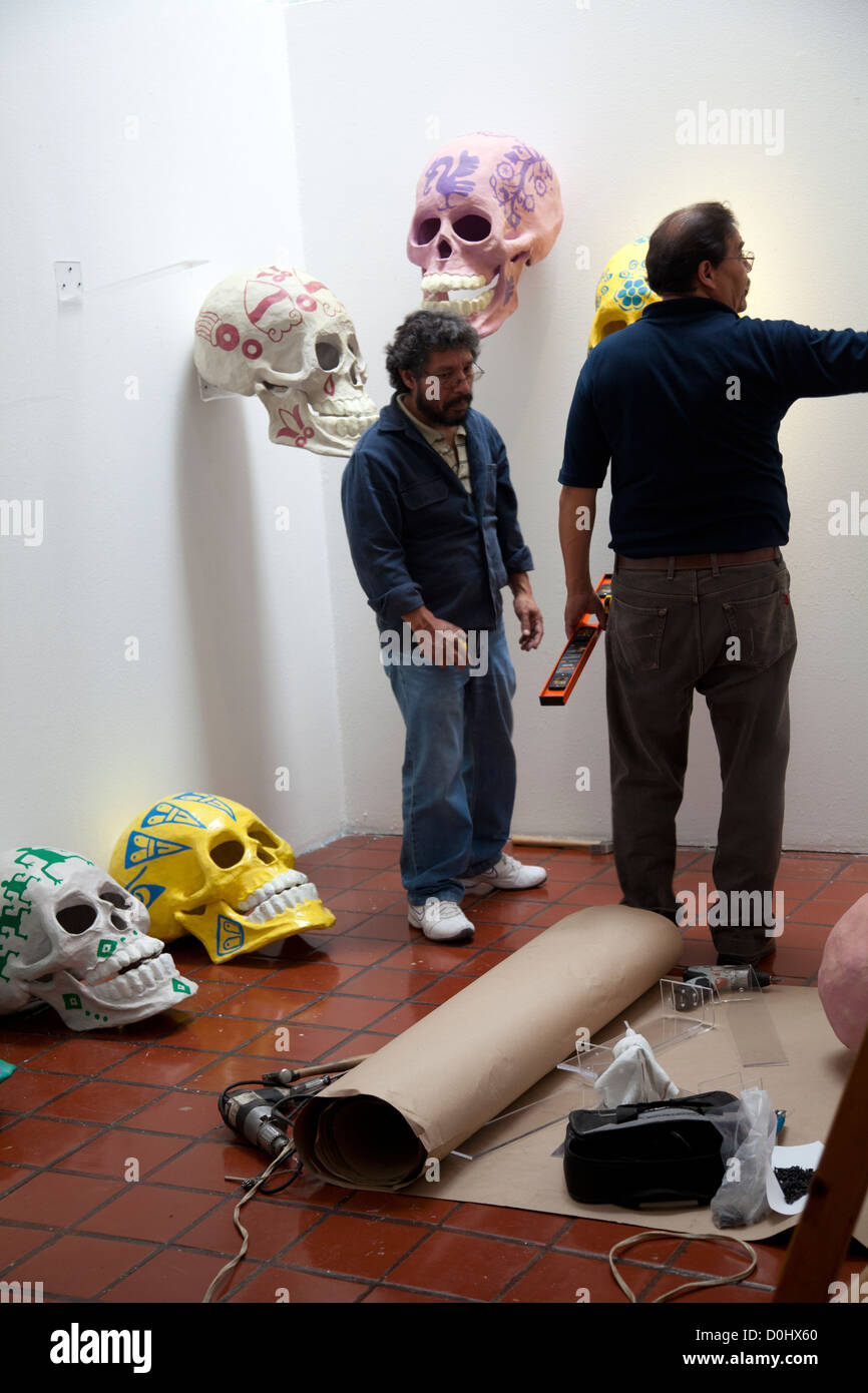 Men Installing Painted Calaveras Exhibit at Museo Nacional de Culturas Popular during Dia de los Muertos Celebrations - Coyoacán Stock Photo