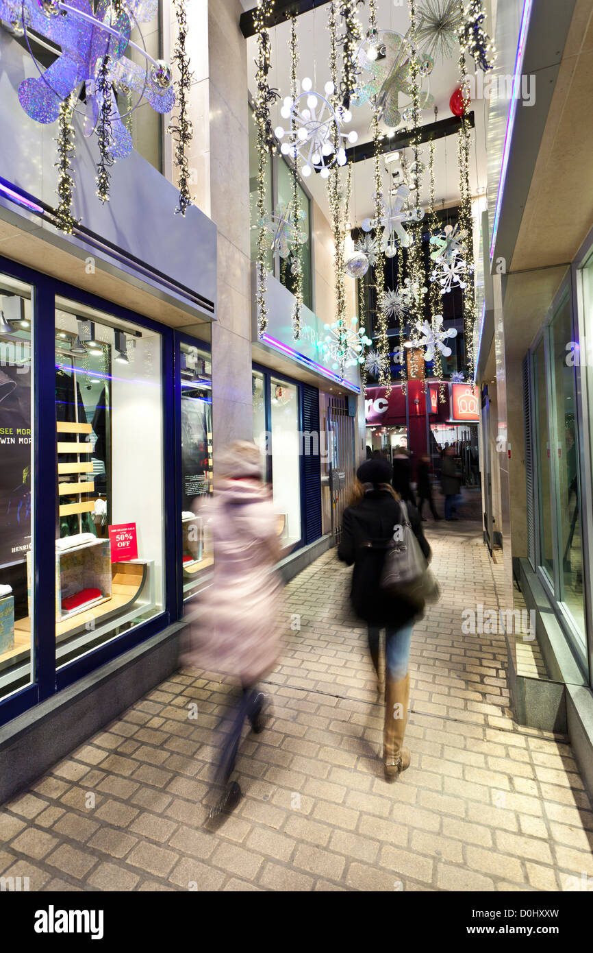 Shoppers walking through an arcade towards Carnaby Street at Christmas time. Stock Photo