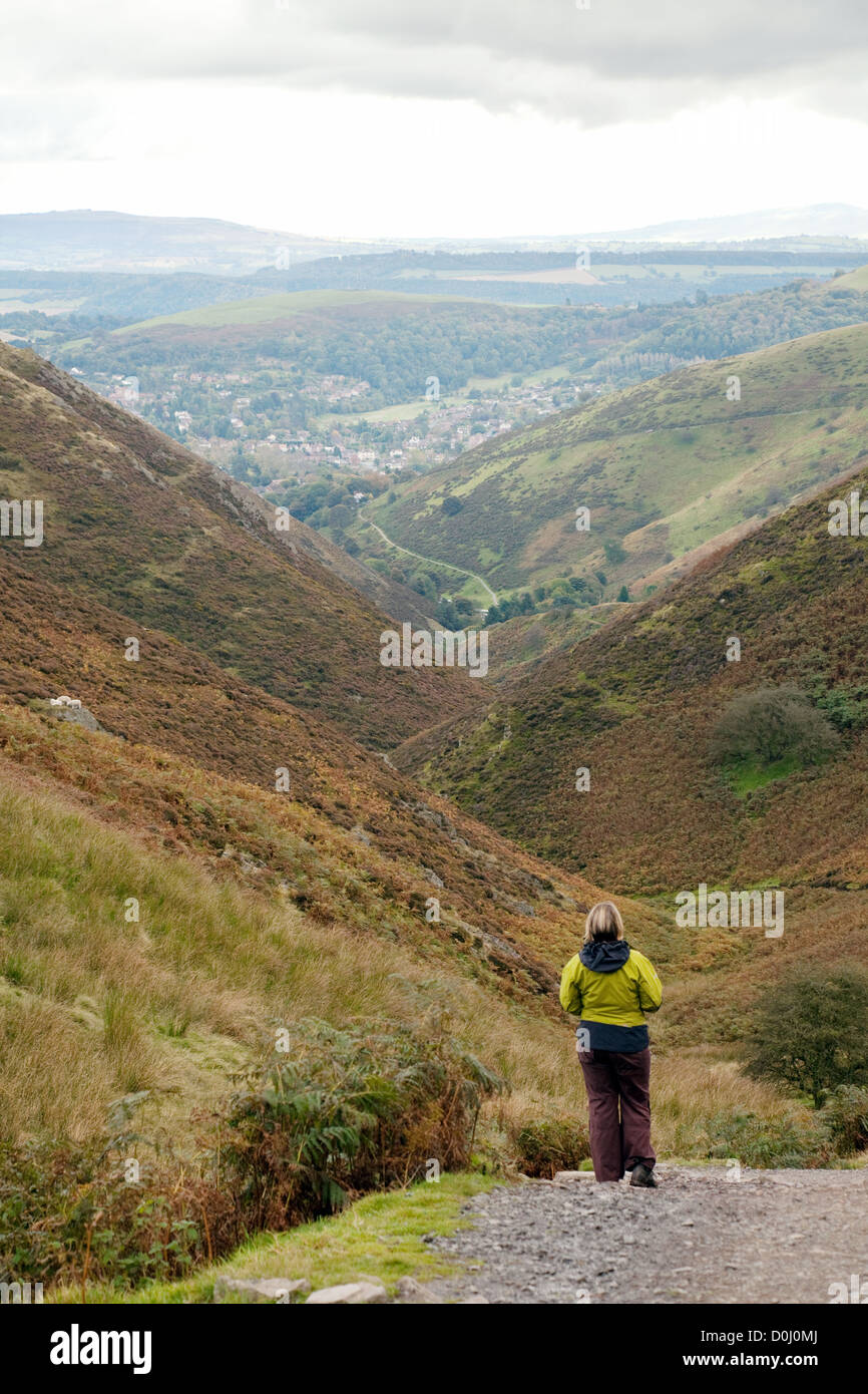 One woman walking on the Long Mynd, Church Stretton in the distance, Shropshire Hills UK Stock Photo