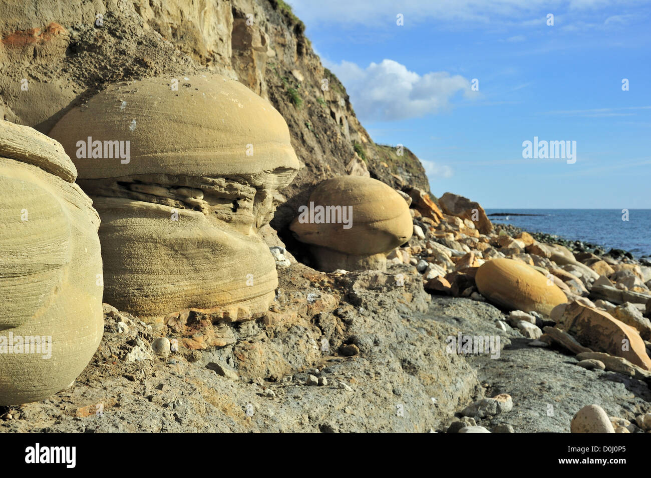 Rounded sandstone nodules on beach near Osmington Mills from Bencliff Grit Formation, Jurassic Coast, Dorset, south England, UK Stock Photo