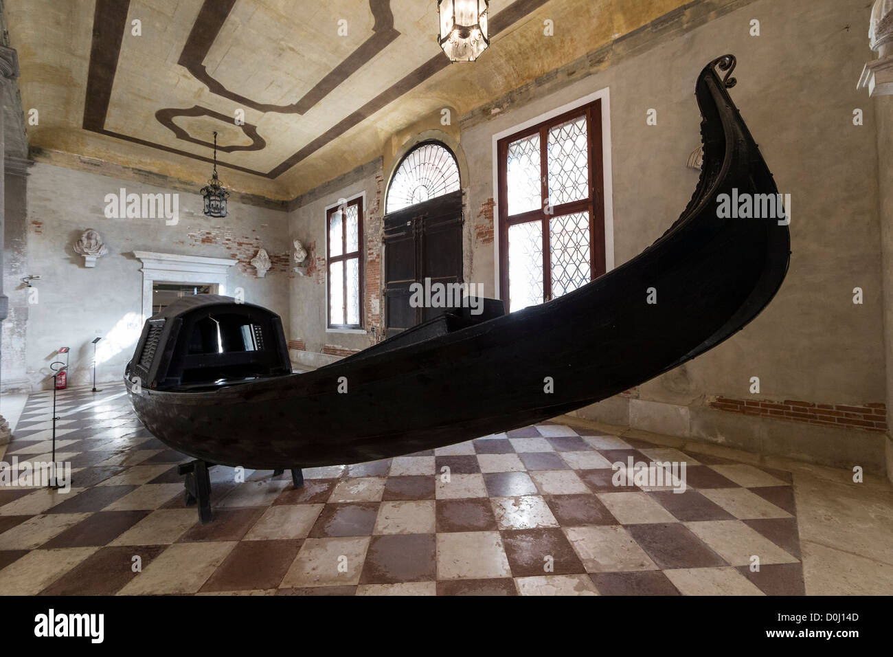 An antique gondola painted black, with a covered cabin, on display at the C'a Rezzonico museum in Venice Stock Photo