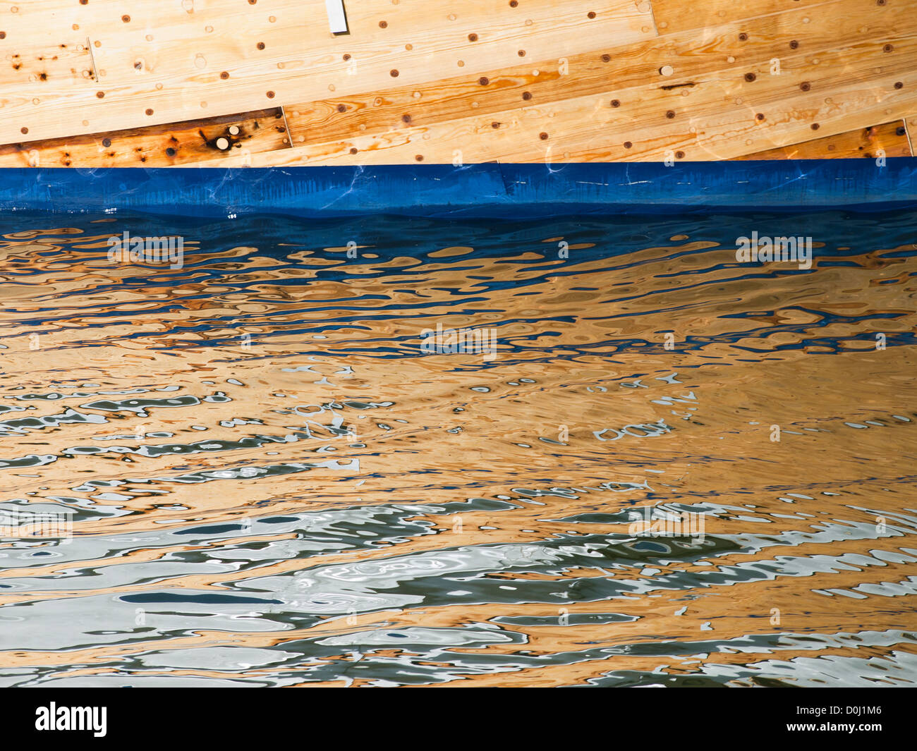 Wooden boat and its reflected image on ripples in the sea water, Oslo ...