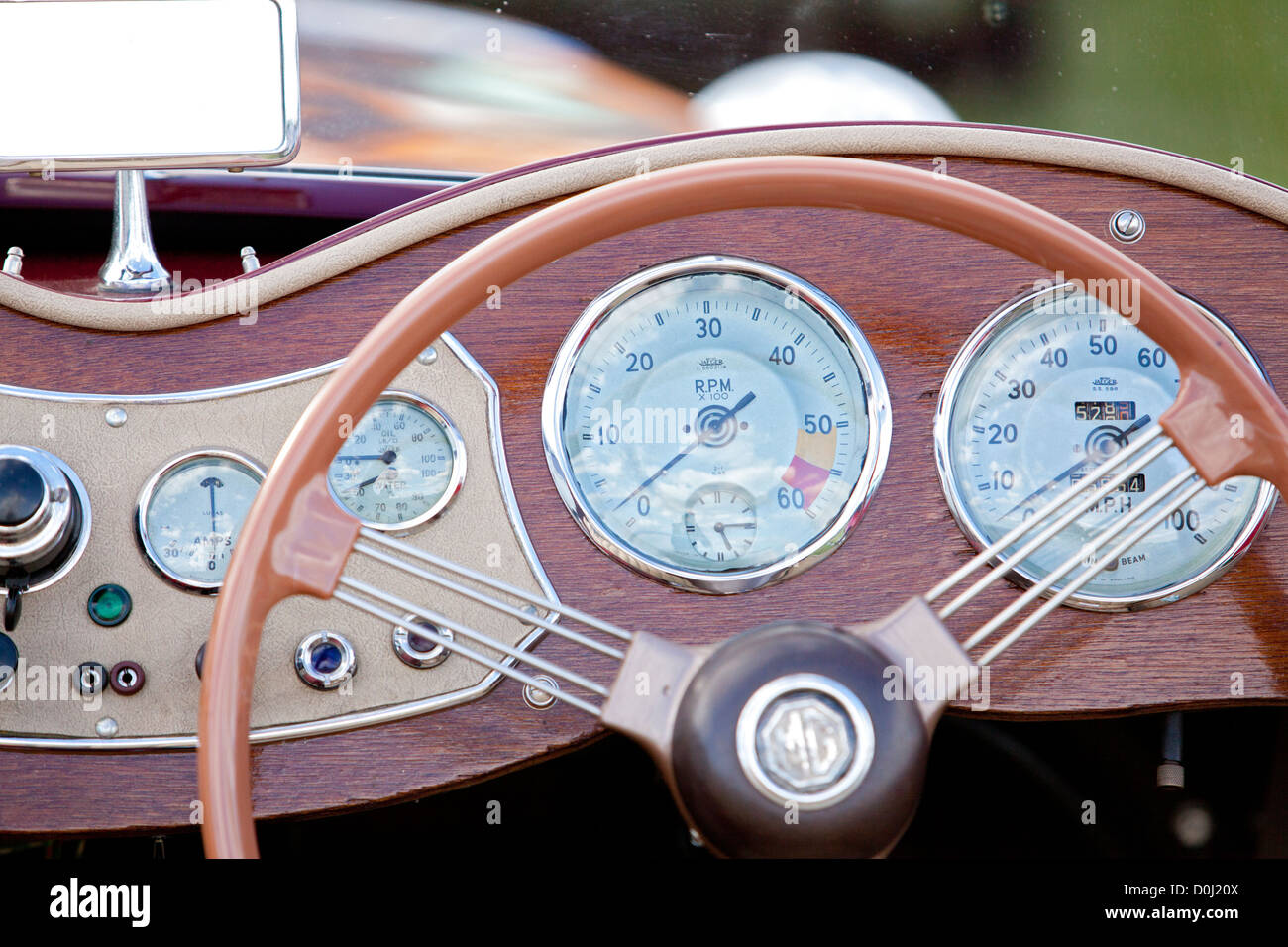 A close up view of the steering wheel and dashboard of a classic car at Goodwood revival. Stock Photo