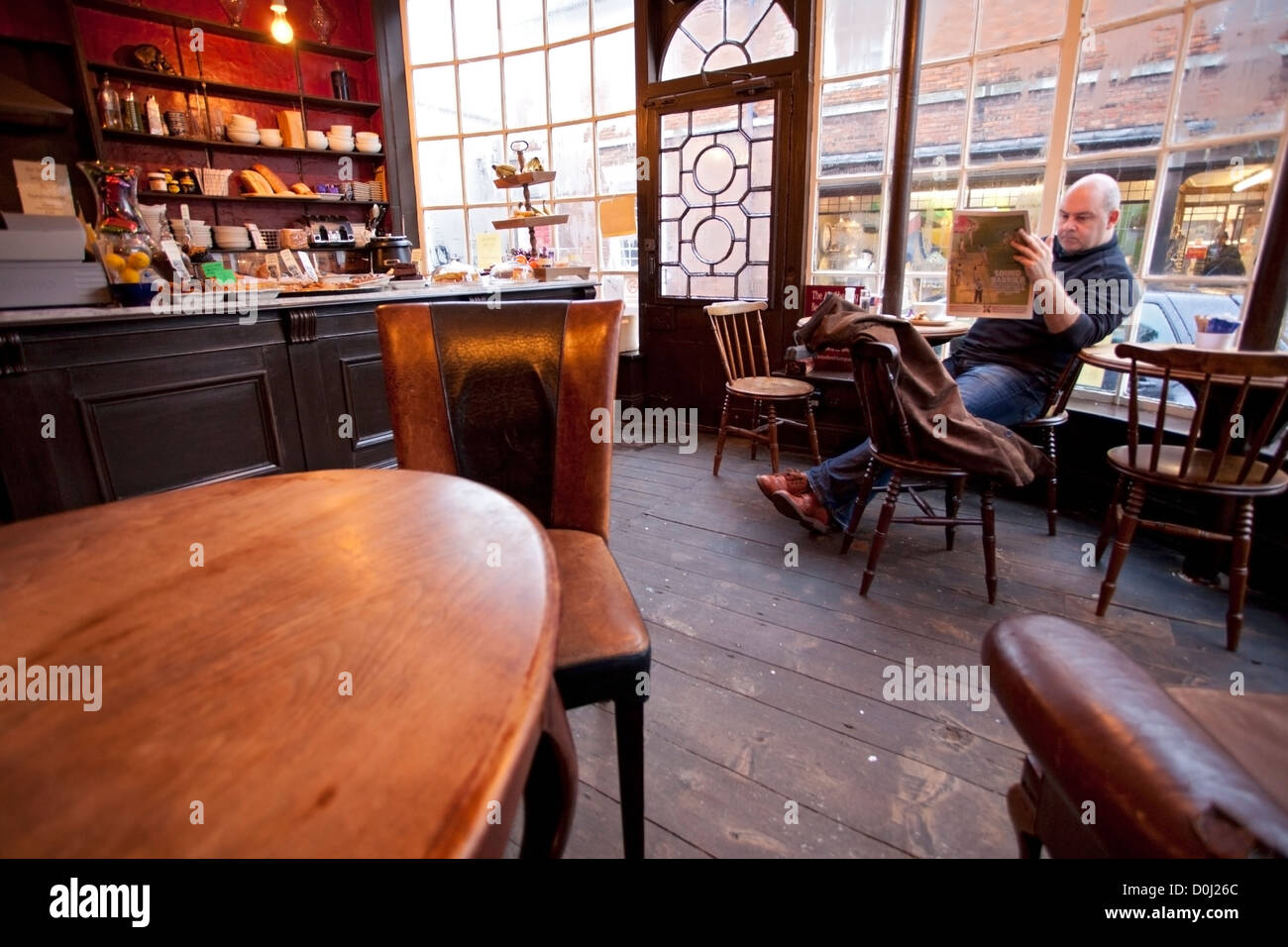 A man relaxes in the Apothecary cafe in Rye. Stock Photo