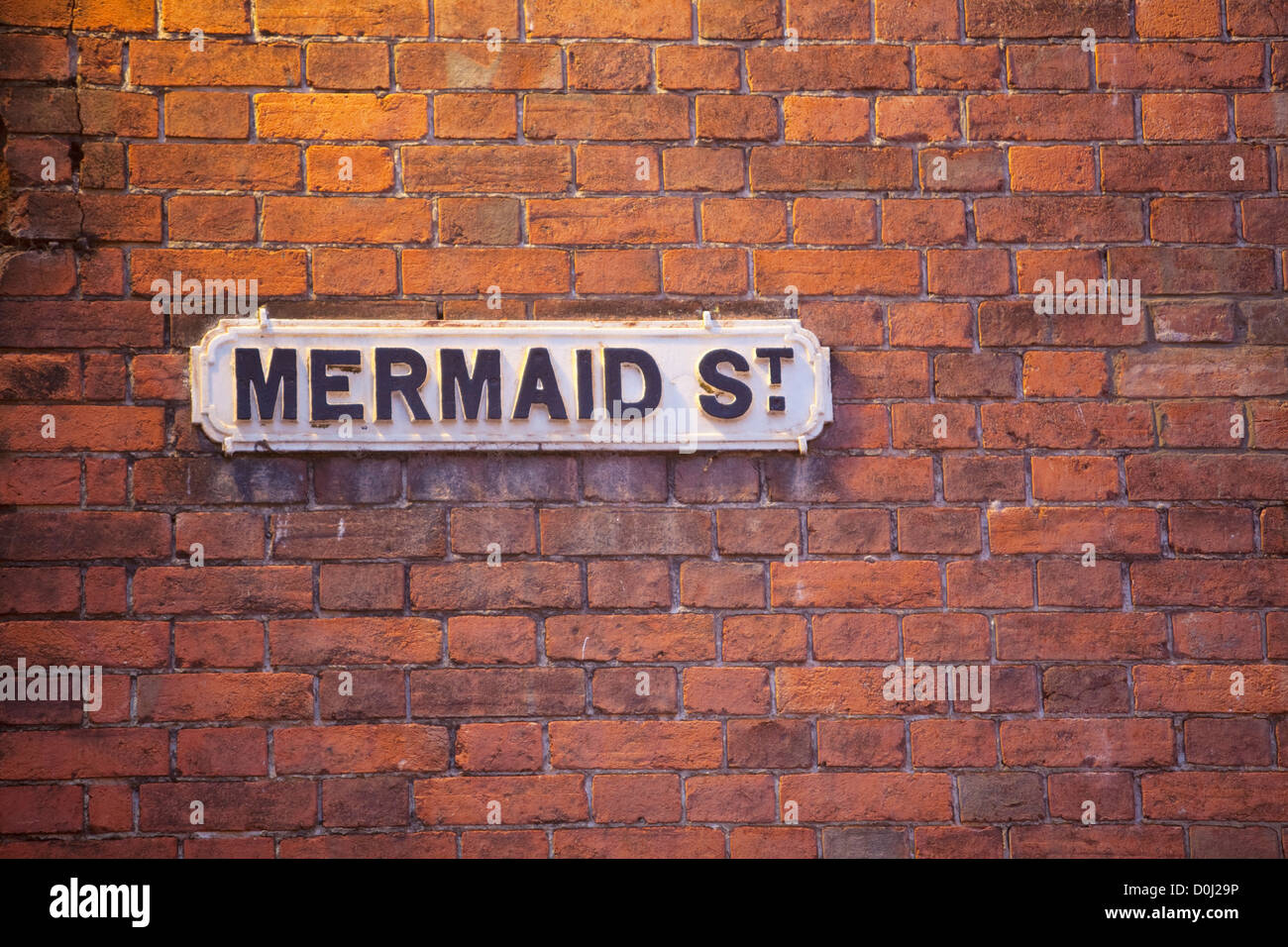 A traditional English town road sign on a victorian brick wall. Stock Photo
