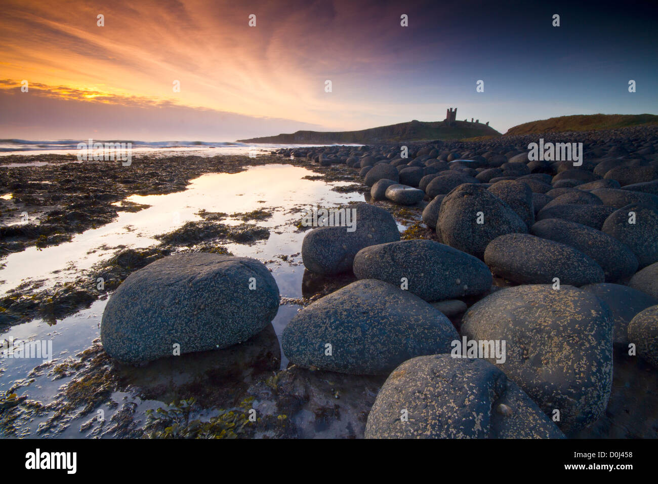 Dunstanburgh Castle at sunrise. Stock Photo