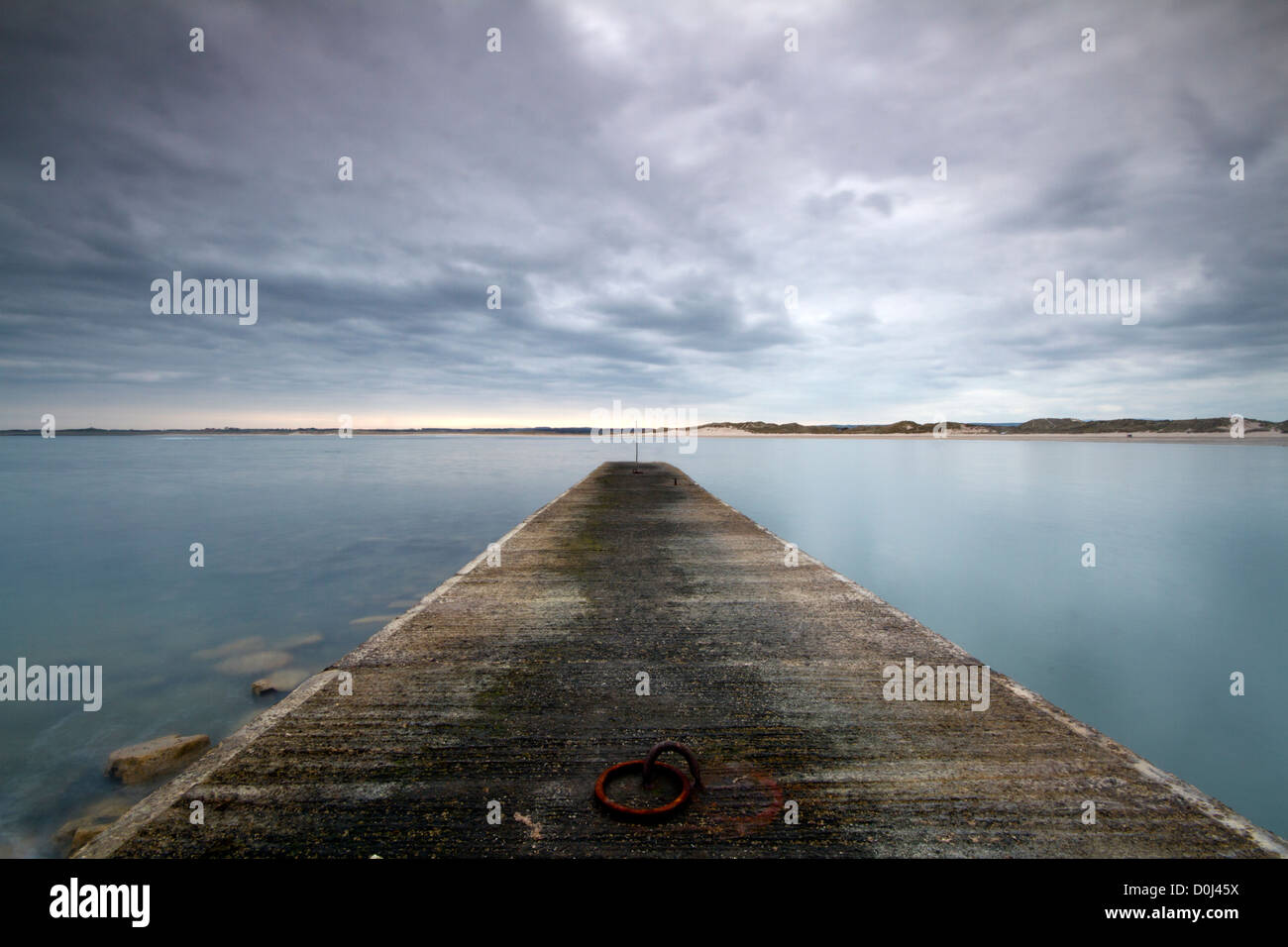 Beadnell Harbour looking across to Bamburgh. Stock Photo