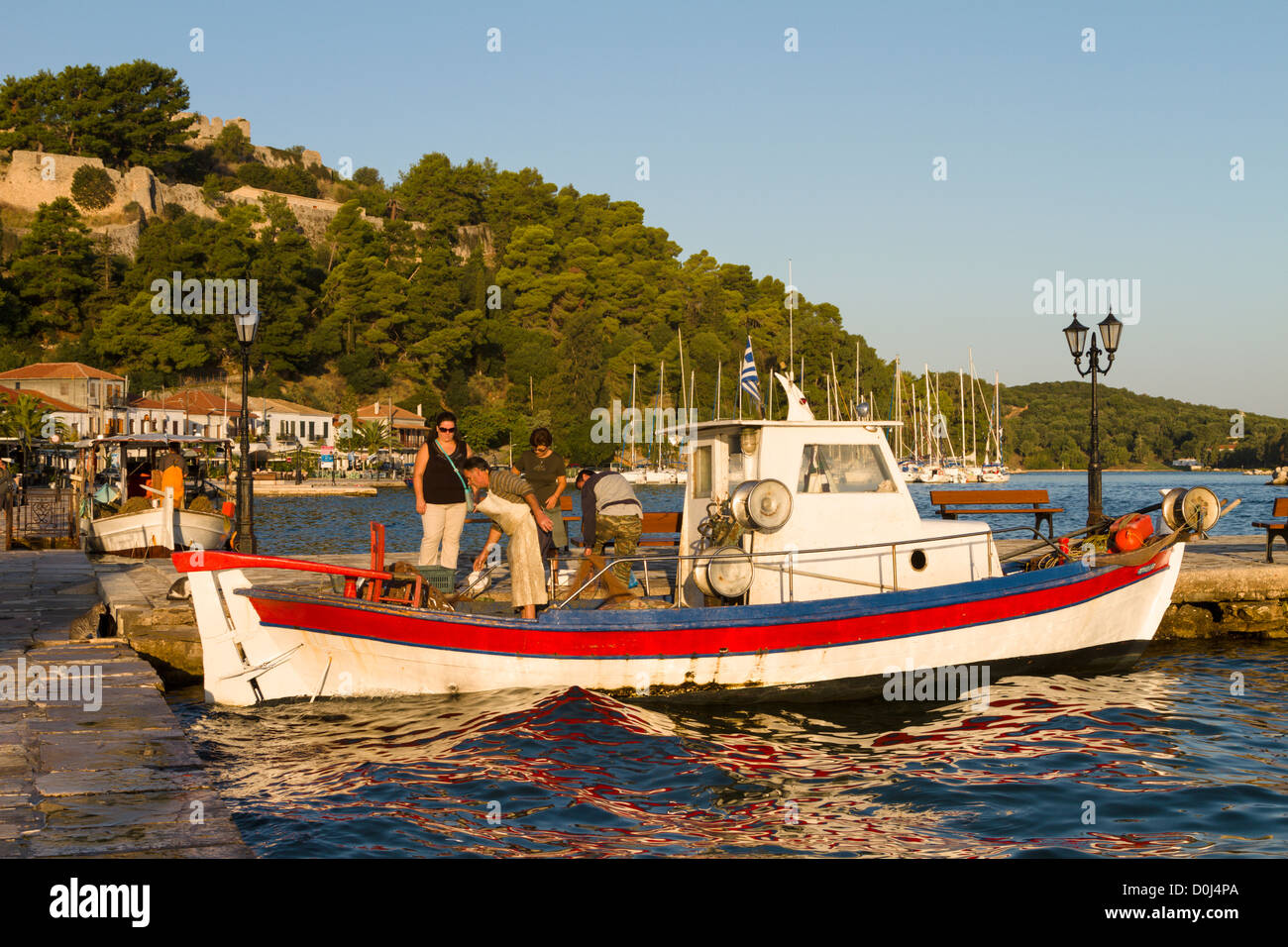 Woman buying fish from fishing boat at Vonitsa, Ambracian Gulf, Greece Stock Photo