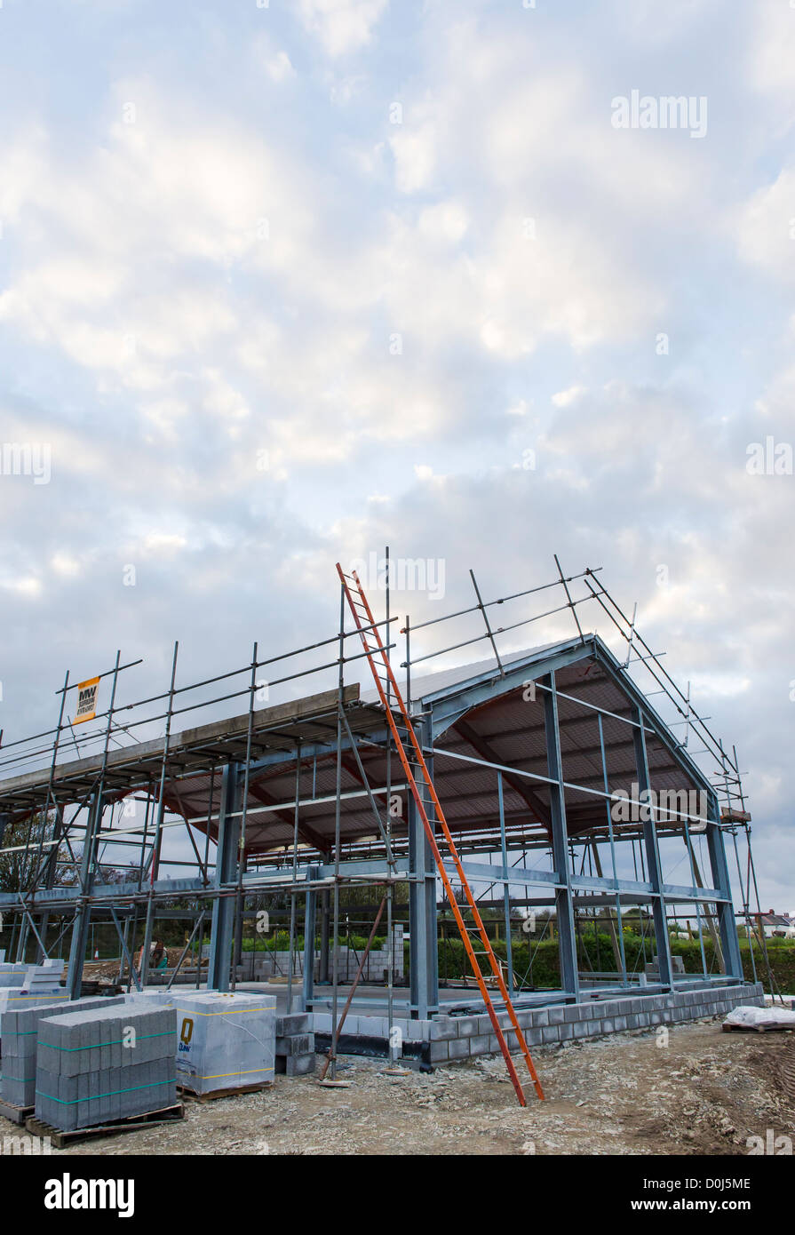 A steel framed industrial building, frame and roof in place.  Soon to be a village hall in Caerwedros West Wales Stock Photo
