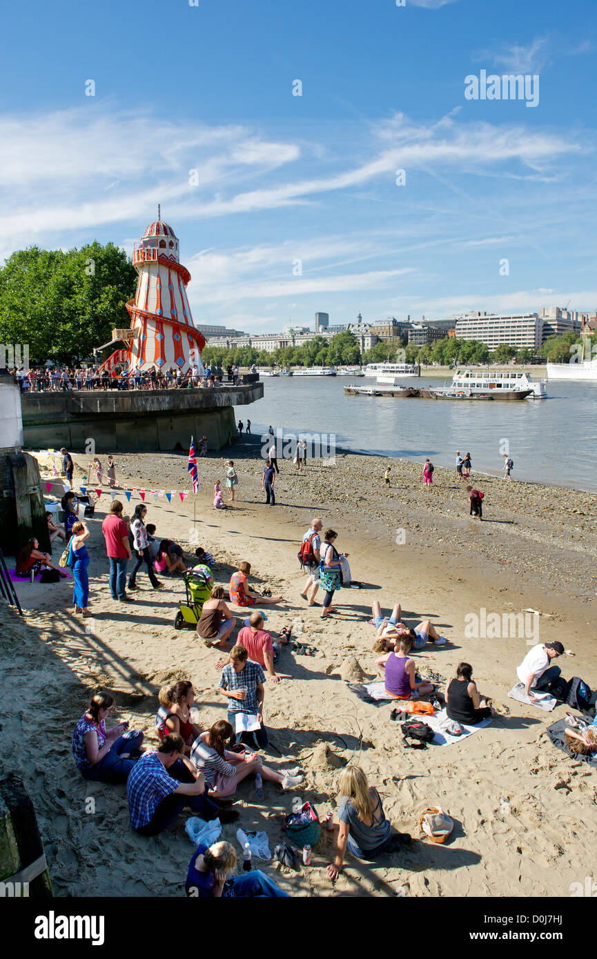 People enjoying themselves on the foreshore of the River Thames. Stock Photo