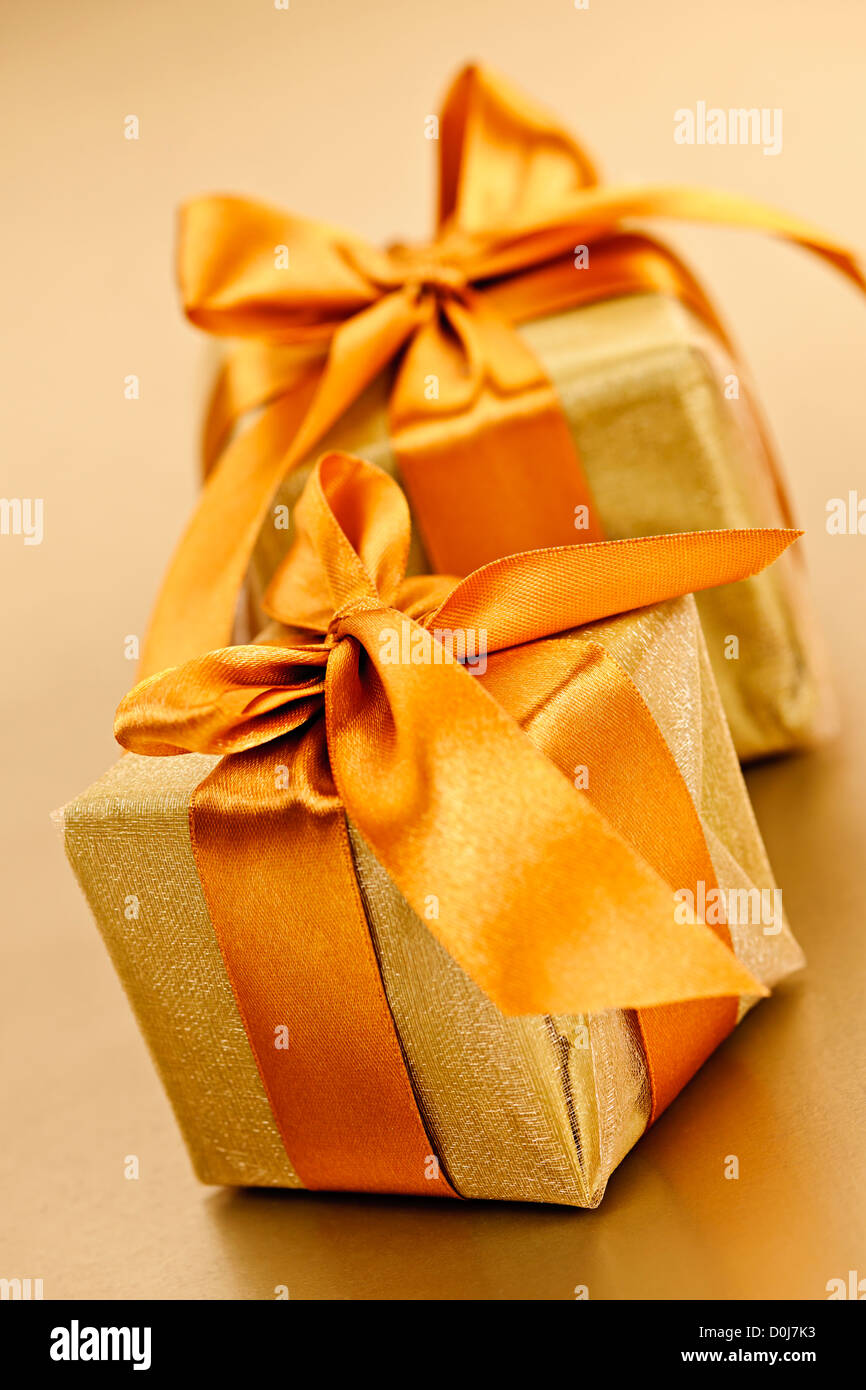 Two gift boxes in gold wrapping paper with ribbon and bow Stock Photo