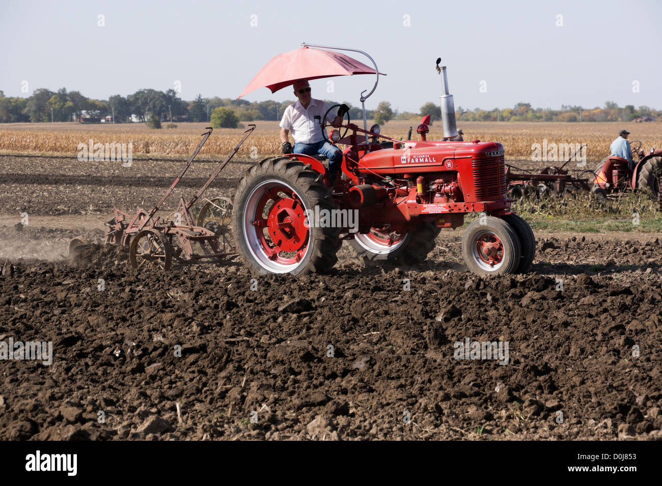 Farmall Model M plowing a field on a farm near Hebron, Illinois during an antique tractor plowing demonstration. Stock Photo