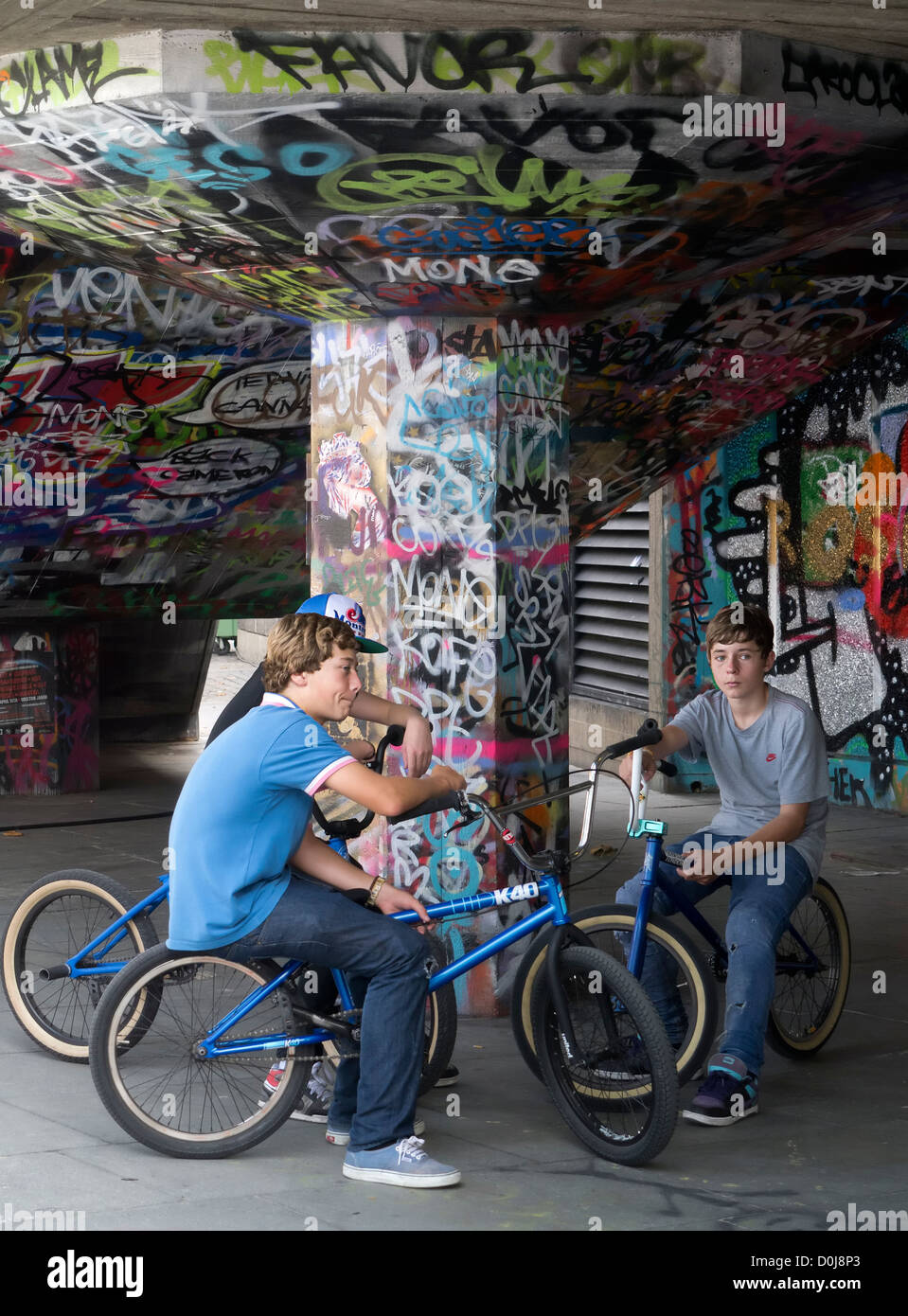 Three cyclists at graffiti-land on the South Bank in London. Stock Photo