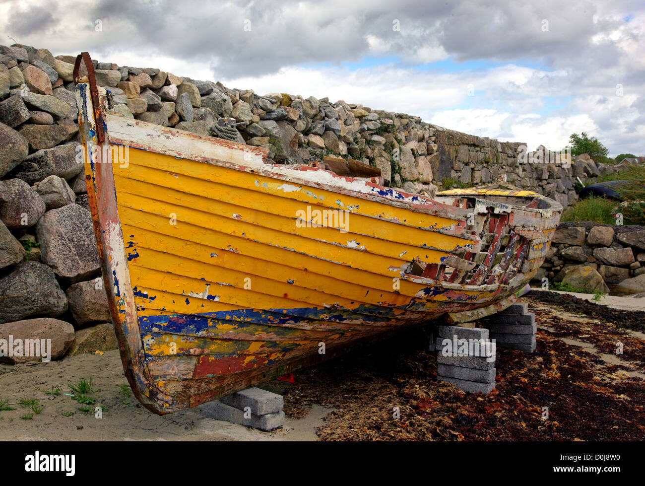 An old fishing boat rotting in the small harbour at Barna, near Galway, Ireland. Stock Photo