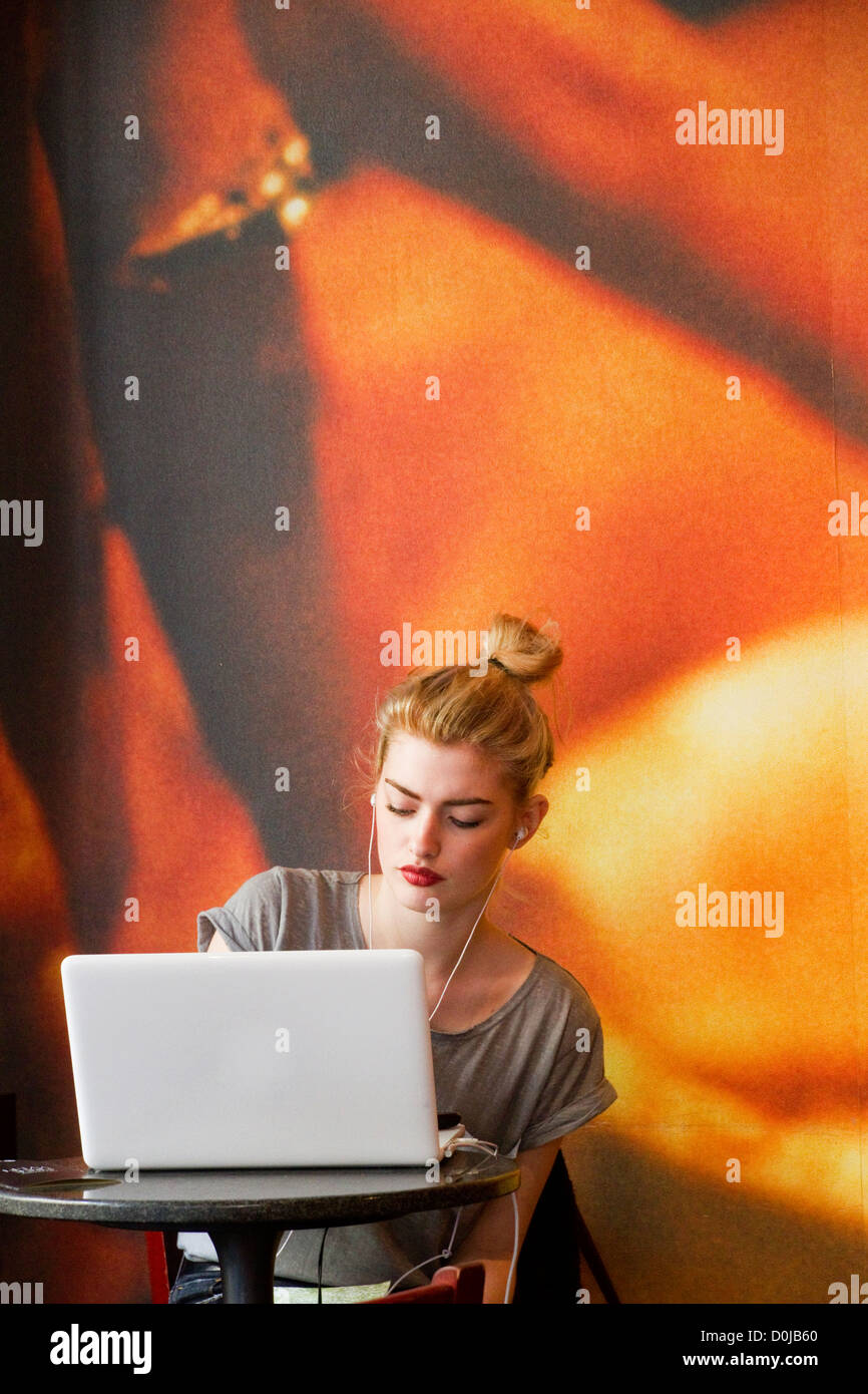 A young woman working at her lap-top in a Soho coffee-shop. Stock Photo