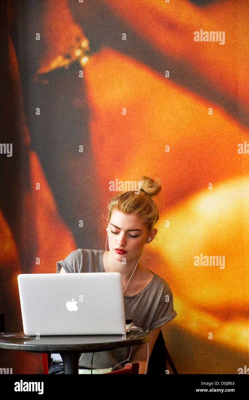 A young woman working at her lap-top in a Soho coffee-shop. Stock Photo