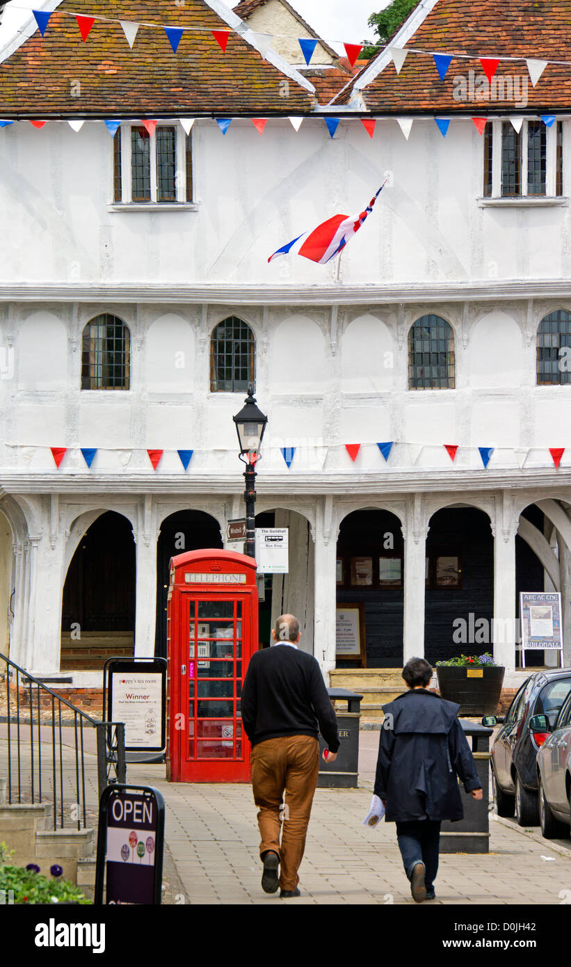 Tourists walk towards the 15th Century Guildhall in Thaxted. Stock Photo