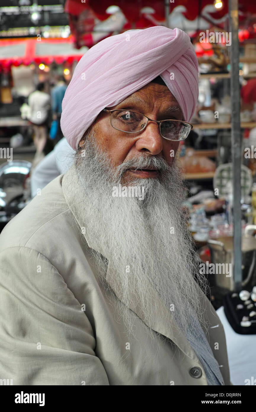 A distinguished storeholder with beard and turban in Spitalfields market in East London. Stock Photo