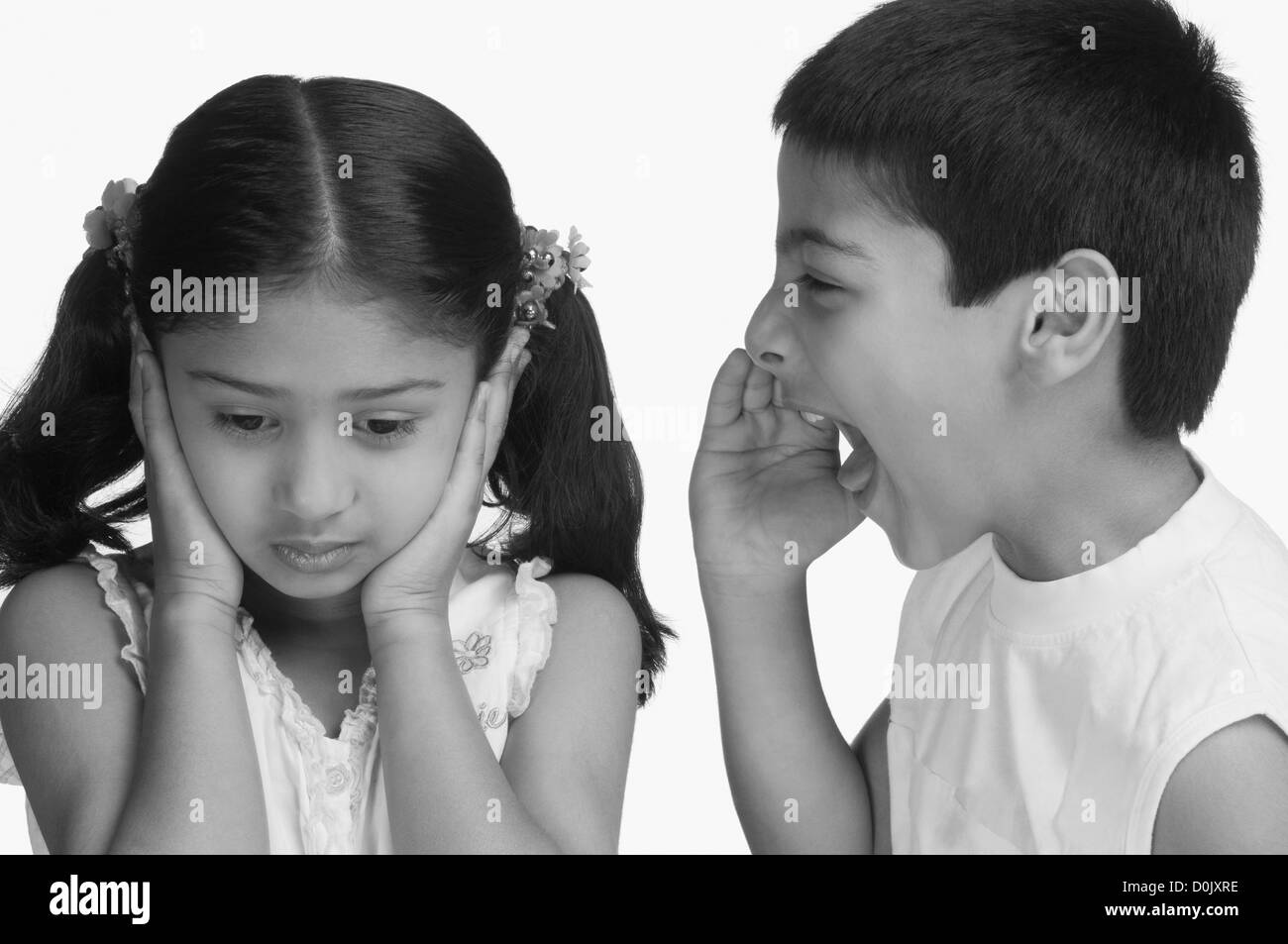 Girl covering her ears while her brother shouting Stock Photo Alamy