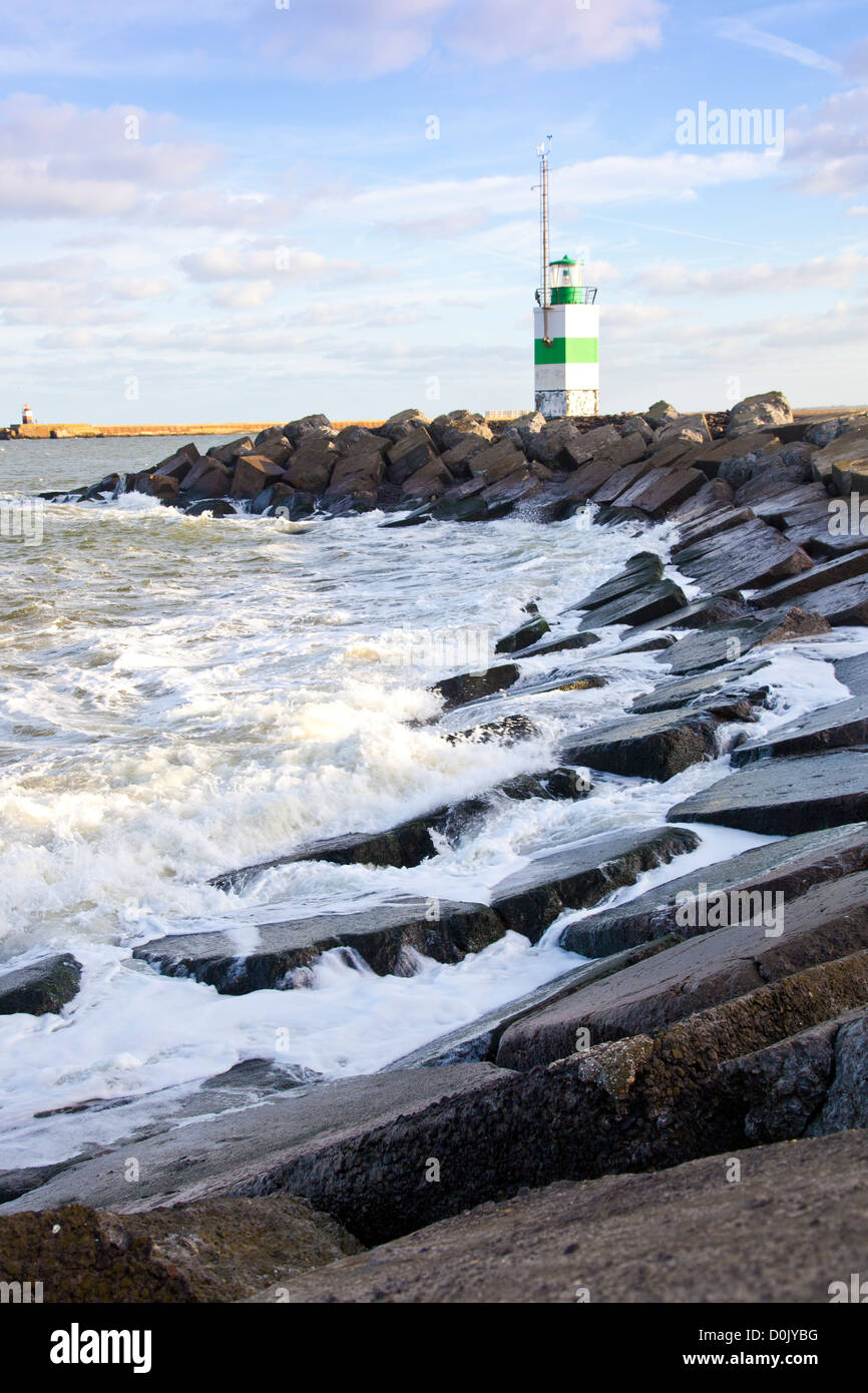 Lighthouse By Rocks Little lighthouse with rocks and blue sky Stock Photo - Alamy