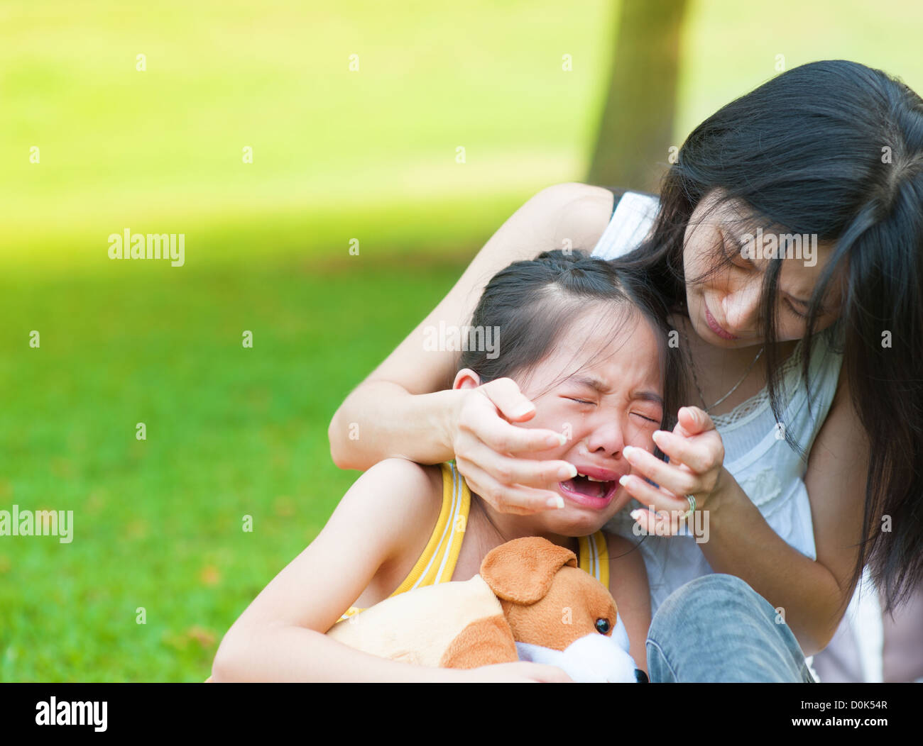 Asian Mother Is Comforting Her Crying Daughter Stock Photo