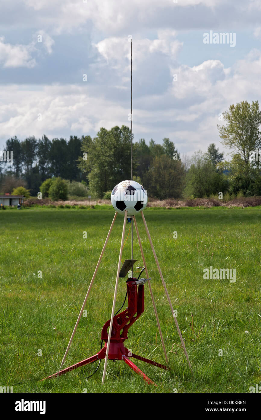 A model rocket made from a soccer ball sits on a launch platform at a