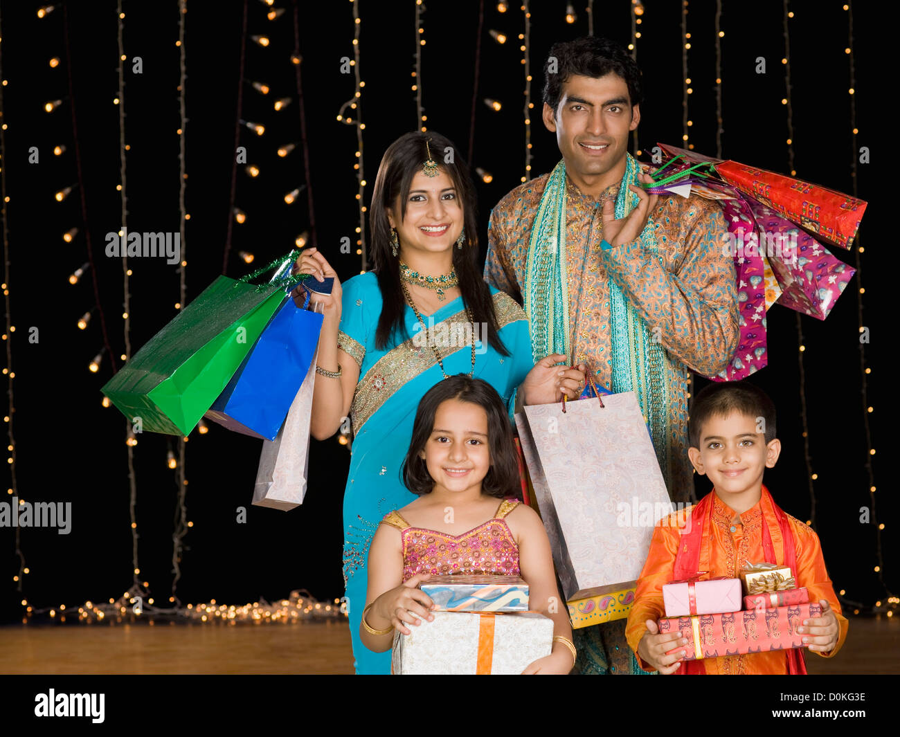 Family with shopping bags in front of Diwali decorations Stock Photo