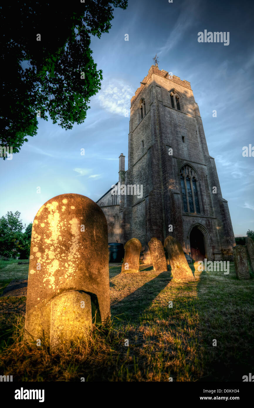 Part of the 14th Century tower of Wisbech St Mary church with gravestones. Stock Photo
