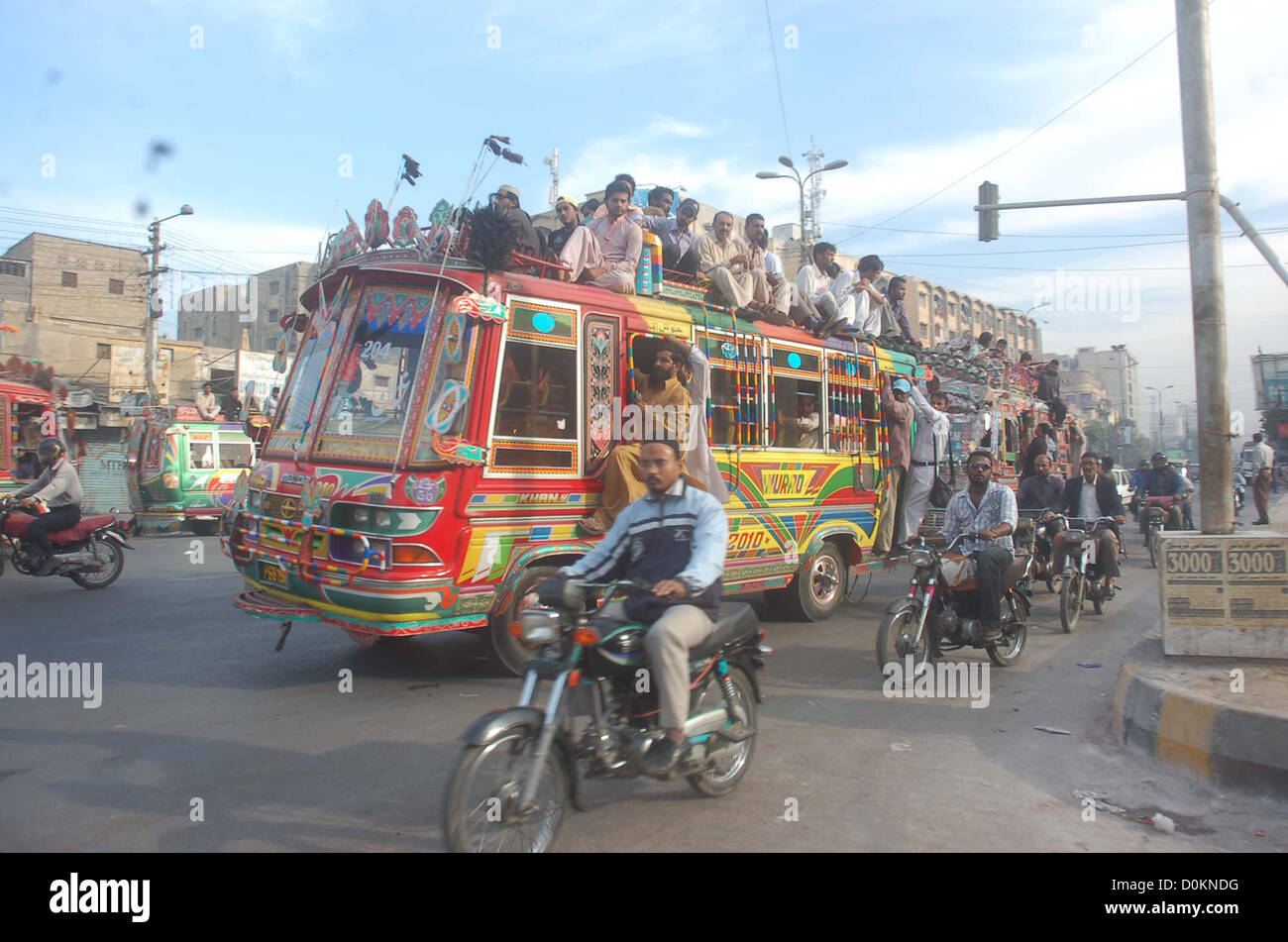 Passengers travel on an overload bus due to non-availability  of passenger buses in Karachi on Tuesday, November 27, 2012. Shortage of transportation  observed in Karachi due to unofficial strike call by the CNG Pumps owners against highly- unreasonable retail price of CNG that is causing them massive financial losses. Stock Photo